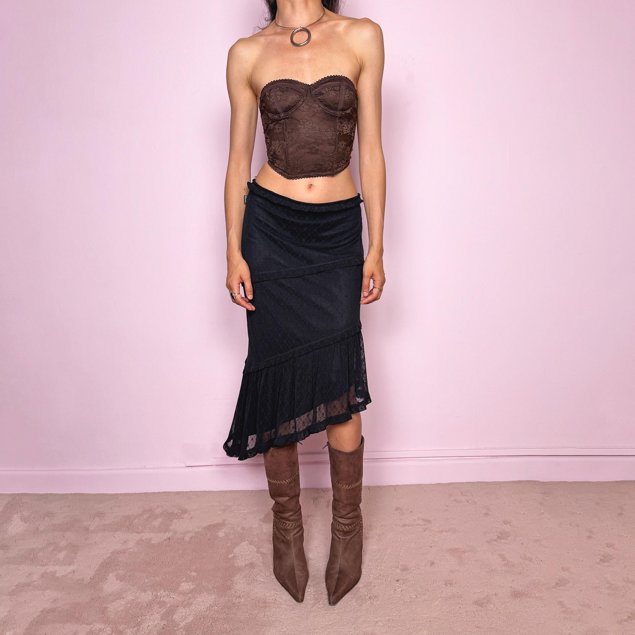 Vintage 2000s Moschino Jeans black lace asymmetric midi skirt made in Italy from a stretchy polyamide fabric. Features a low-rise, soft stretch waistband without elastic, delicate ruffle trim, layered asymmetric panels, and a sheer lace pleated hem. A dark romantic Y2K designer piece, perfect for elevated evening looks. Excellent vintage condition.