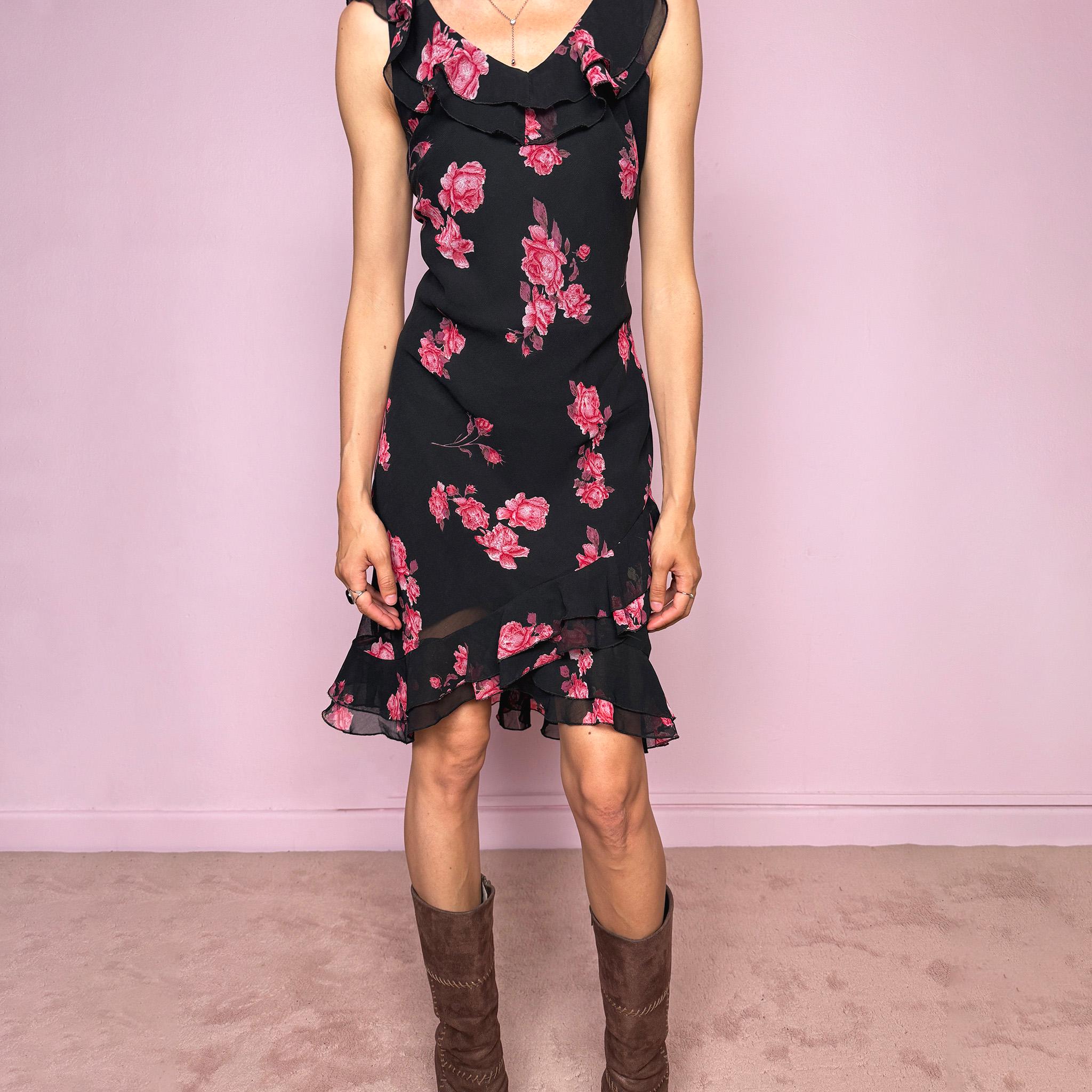 Vintage 2000s black floral mini dress with a romantic 90s feel, pink rose print, sleeveless fitted silhouette, V neckline, ruffled bust and straps, and an asymmetric layered ruffle tulip hem. Ideal for feminine spring and summer looks. Made by a French brand. Great vintage condition.