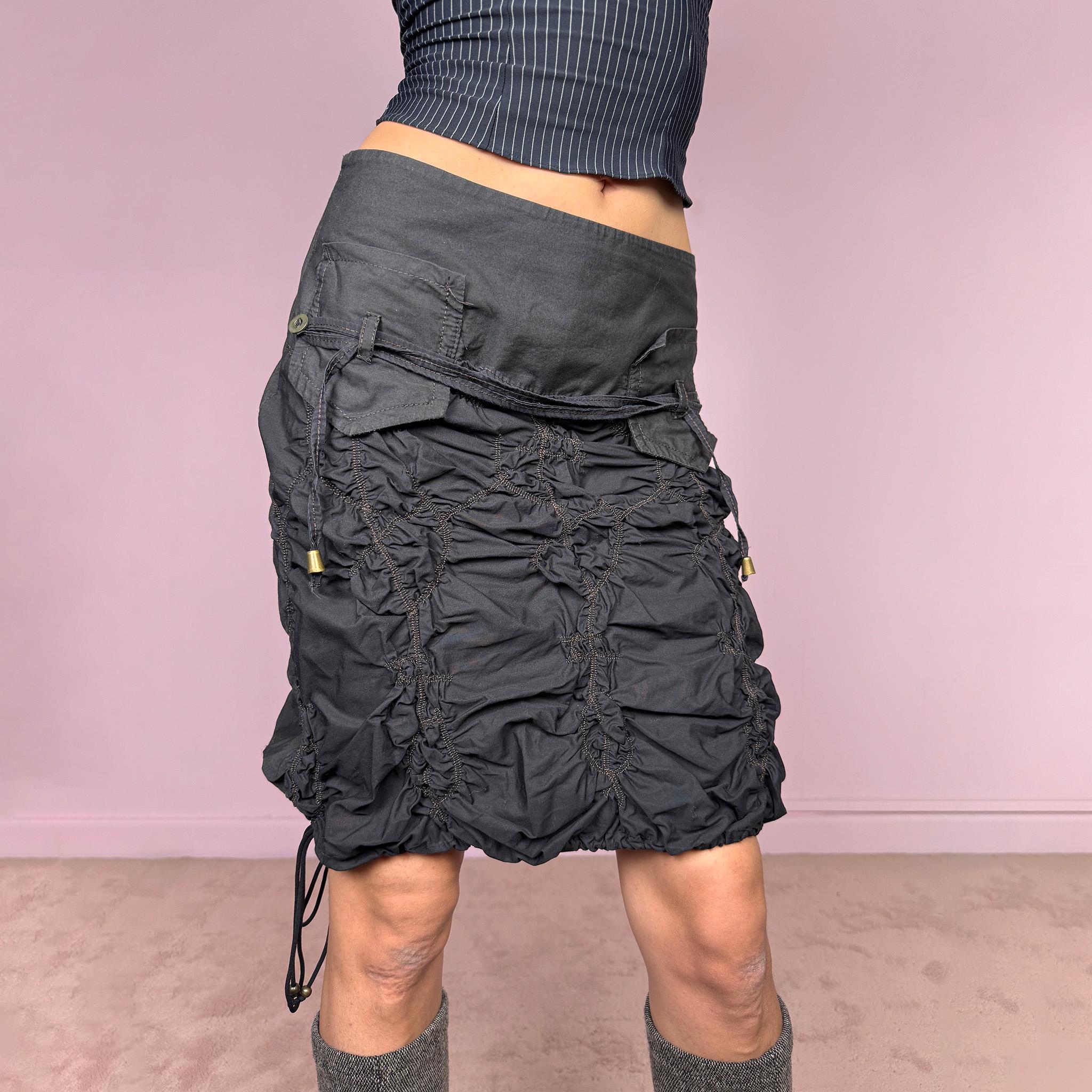 Vintage 2000s black ruched mini skirt crafted from 100% cotton with sculptural gathered texture, dimensional ruching, stitched lattice detailing, adjustable drawstring accents, back button closure, and no stretch. Dark Y2K cyber dystopian utility aesthetic. Can be worn mid rise for size S or lower rise for XS. Made in France from a French brand. Great vintage condition.