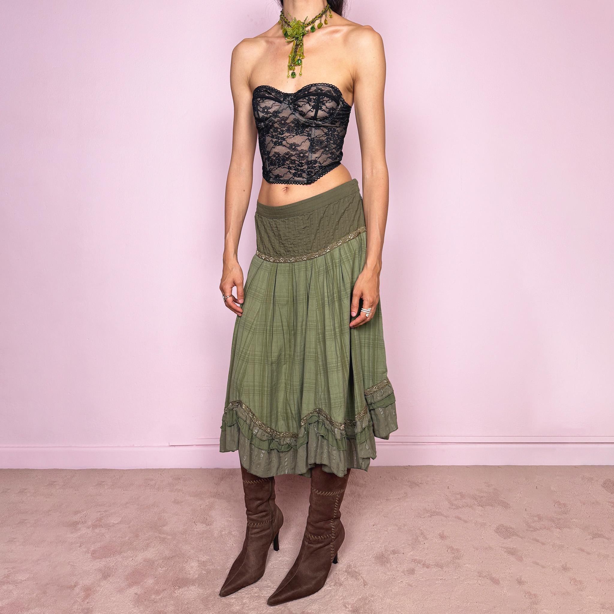 Vintage 2000s olive green khaki midi skirt with a soft bohemian feel, featuring a gathered silhouette, pleated waist panel, and layered ruffle hem with floral embroidered trim details. Designed in non-stretch 100% cotton fabric with a side zip closure, the skirt has a romantic, earthy look. Can be worn mid-rise for size L. Great vintage condition.