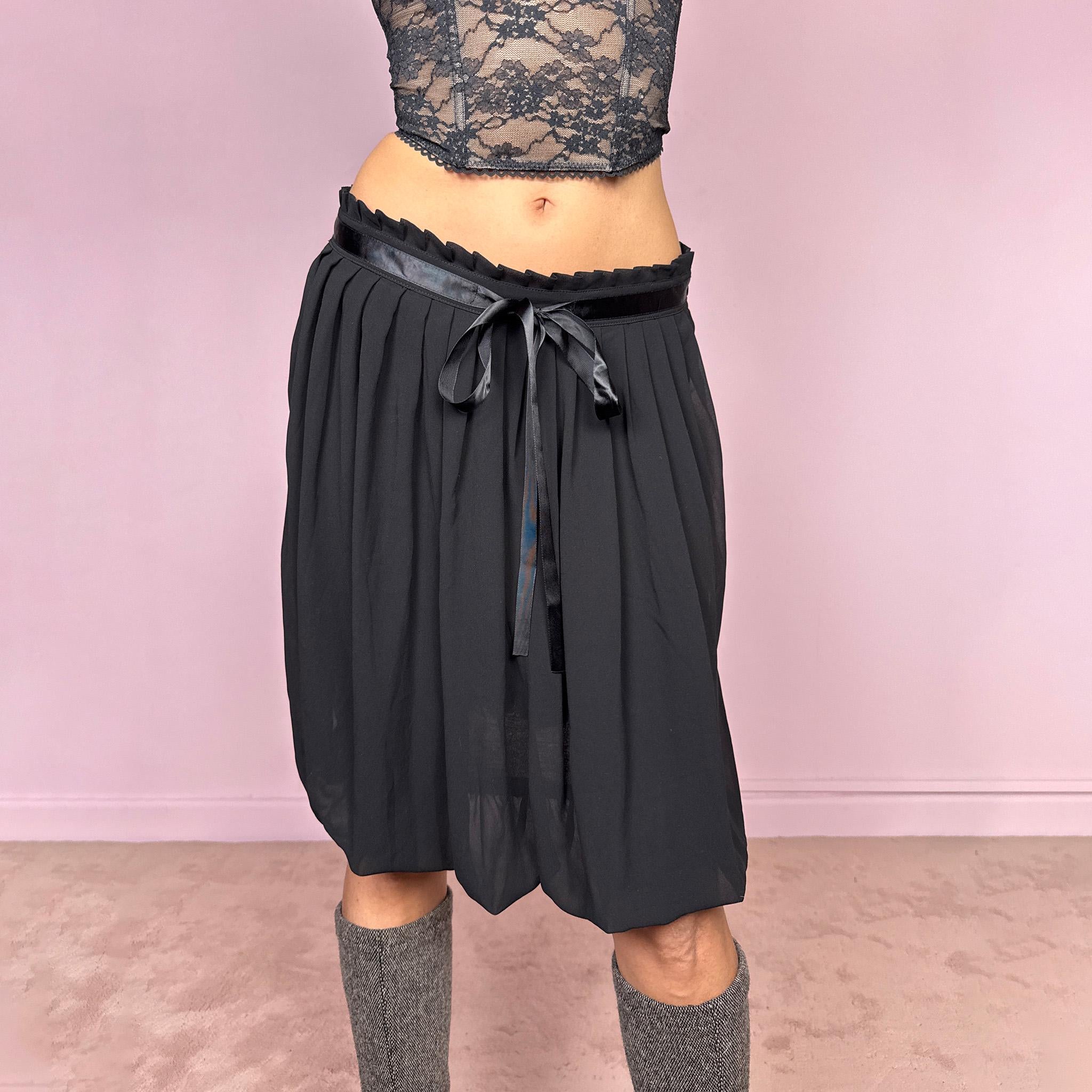 Vintage 2000s black bubble hem midi skirt featuring a pleated silhouette with side zip closure, front tie detail, and voluminous bubble hem. Romantic yet minimal with a subtle coquette party mood, ideal for formal occasions, evening looks, or darker feminine everyday styling. Can be worn high waisted for M or lower rise for S. From a French brand. Excellent vintage condition.