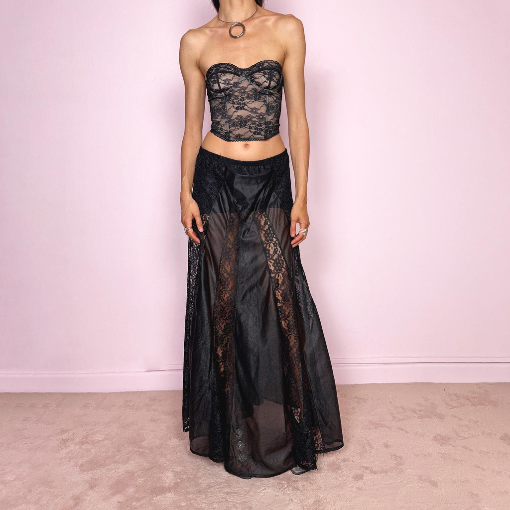 Vintage 90s black gothic maxi skirt with an elasticated waist and dramatic floor-length silhouette. Features sheer lace panels, semi-transparent mesh sections, and layered fabric construction for a dark romantic lingerie-inspired finish. Can be worn high waisted for M or lower rise for S. Made from 100% polyester. Great vintage condition.