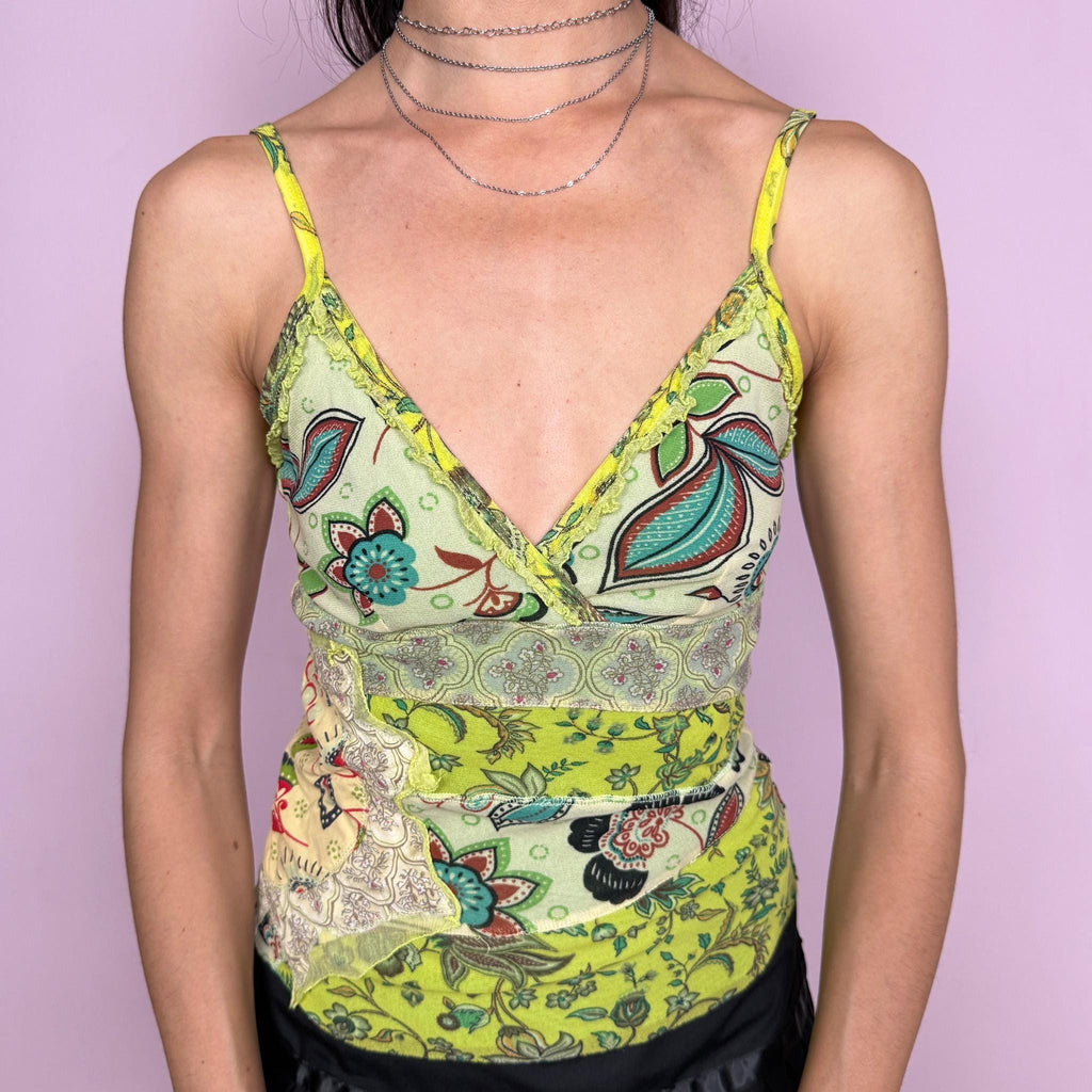 Vintage 2000s green patchwork mesh top with a fitted stretchy silhouette, spaghetti straps, wrap-style neckline, mixed paisley and floral prints, exposed stitching, raw hem and soft ruffle details along the bust. Lightweight with a bohemian Y2K feel, perfect for maximalist summer looks. From a French brand. Excellent vintage condition.