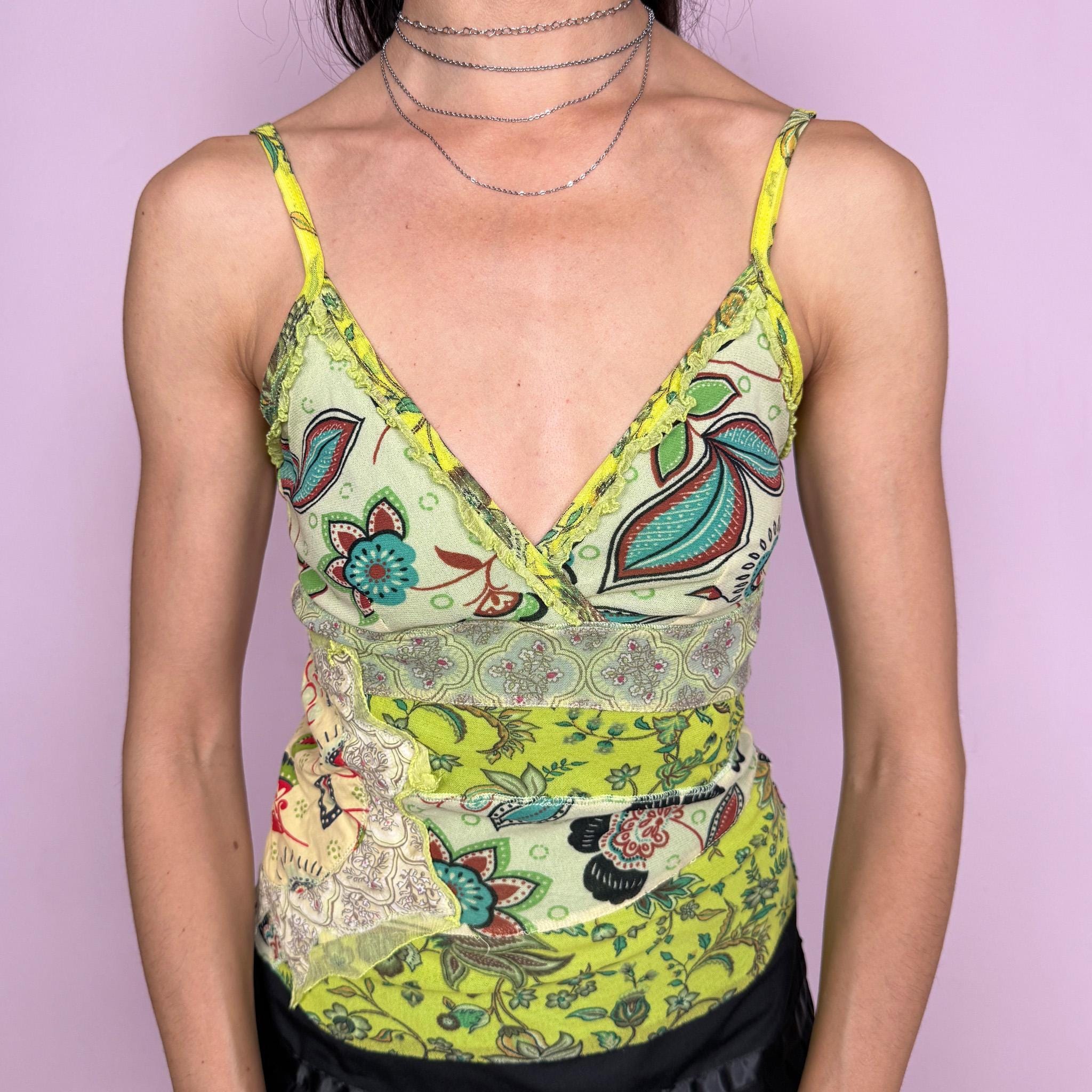 Vintage 2000s green patchwork mesh top with a fitted stretchy silhouette, spaghetti straps, wrap-style neckline, mixed paisley and floral prints, exposed stitching, raw hem and soft ruffle details along the bust. Lightweight with a bohemian Y2K feel, perfect for maximalist summer looks. From a French brand. Excellent vintage condition.