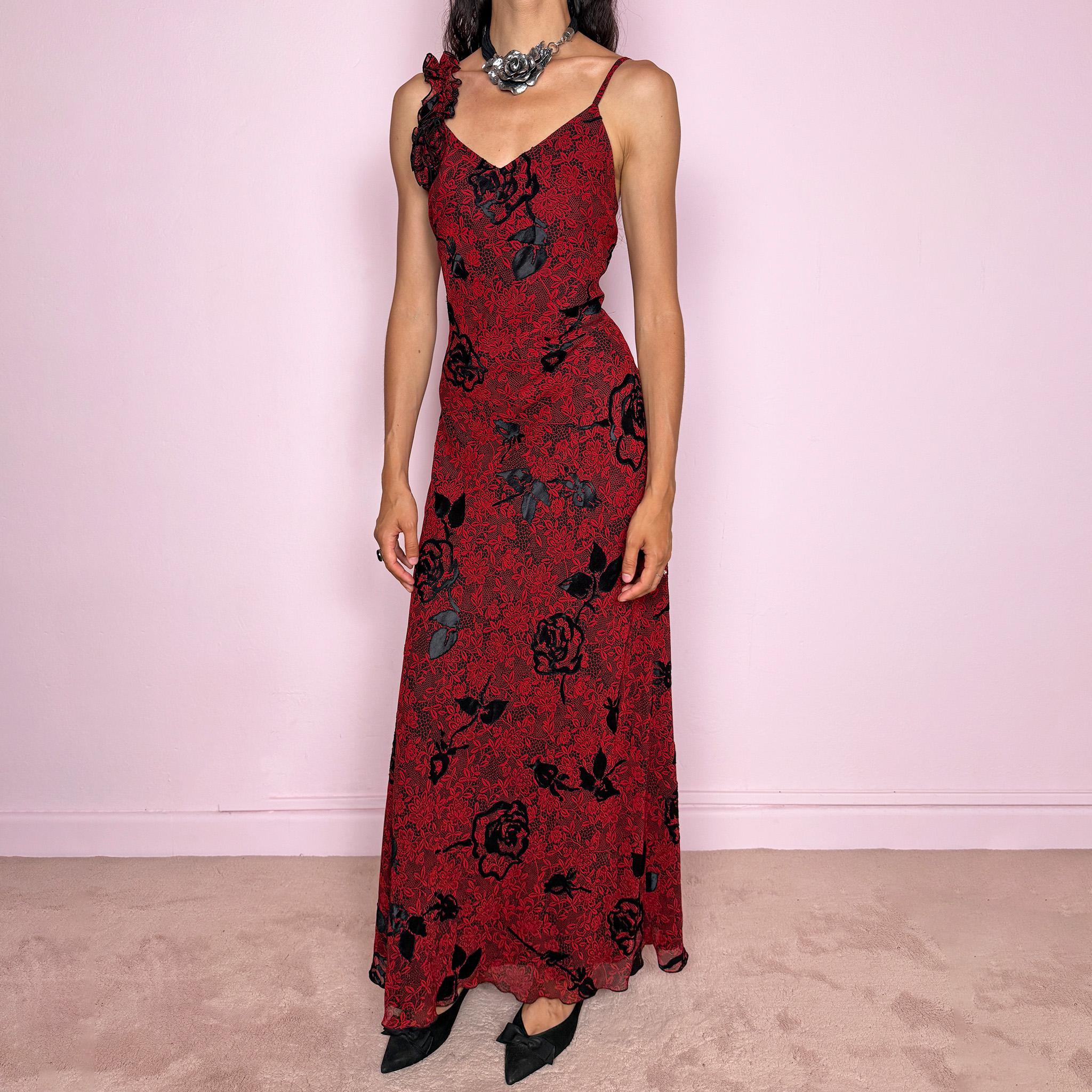 Vintage 2000s red and black floral maxi dress with a fitted silhouette, spaghetti straps, and a dramatic ruffle detail at one shoulder. Designed with a V neckline, long flowing skirt, and black floral motifs over a deep red base, creating a dark romantic evening look. Lightweight with no stretch, a softly semi-sheer outer layer, and black lining, perfect for formal occasions. Composition label is missing, so the exact fabric is unknown. Excellent vintage condition.