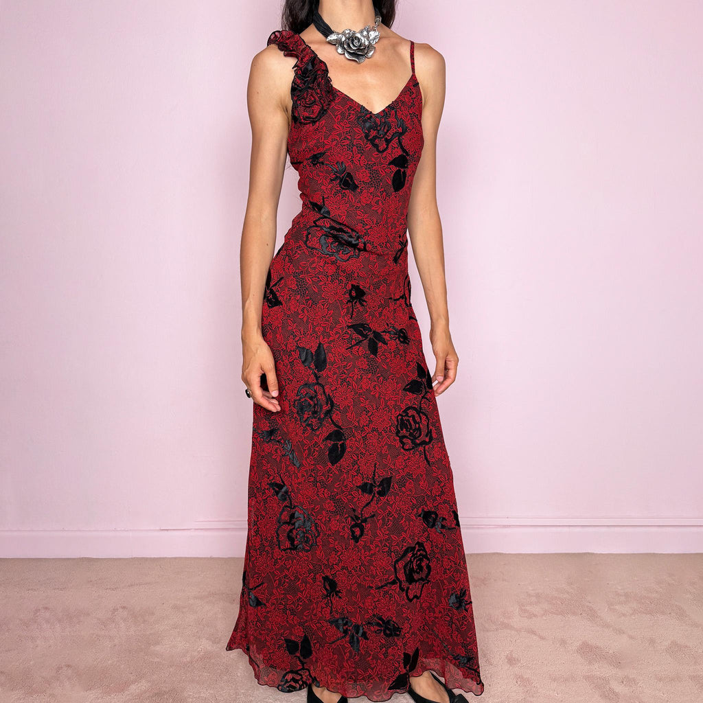 Vintage 2000s red and black floral maxi dress with a fitted silhouette, spaghetti straps, and a dramatic ruffle detail at one shoulder. Designed with a V neckline, long flowing skirt, and black floral motifs over a deep red base, creating a dark romantic evening look. Lightweight with no stretch, a softly semi-sheer outer layer, and black lining, perfect for formal occasions. Composition label is missing, so the exact fabric is unknown. Excellent vintage condition.
