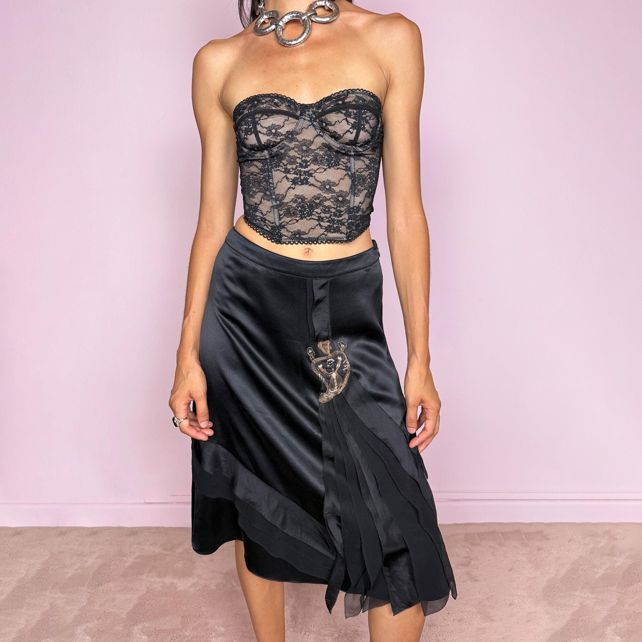 Vintage 2000s Kenzo black midi skirt crafted from 100% silk in a deep black satin finish, designed with a side zip closure and a structured no-stretch fit. It features a dramatic front detail with layered sheer pleated silk panels and an embroidered appliqué motif. A refined designer piece with a dark romantic evening feel, balancing minimal black silk with ornate Kenzo detailing. Can be worn high-waisted for size S, or slightly lower on the waist for XS and XXS. Excellent vintage condition.