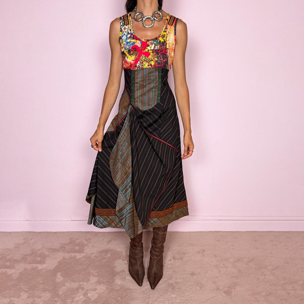 Vintage 2000s midi dress designed with a dramatic medieval-inspired avant-garde silhouette. It features a graphic bust panel with vivid abstract artwork, a fitted corset-effect waist with striped and patterned panels, a side zip closure, and a flowing asymmetric skirt with mixed striped fabrics, contrast trims, and layered draped sections for sculptural movement. Only the bust area has stretch, while the rest of the dress  A rare fantasy statement piece with a theatrical baroque feel.