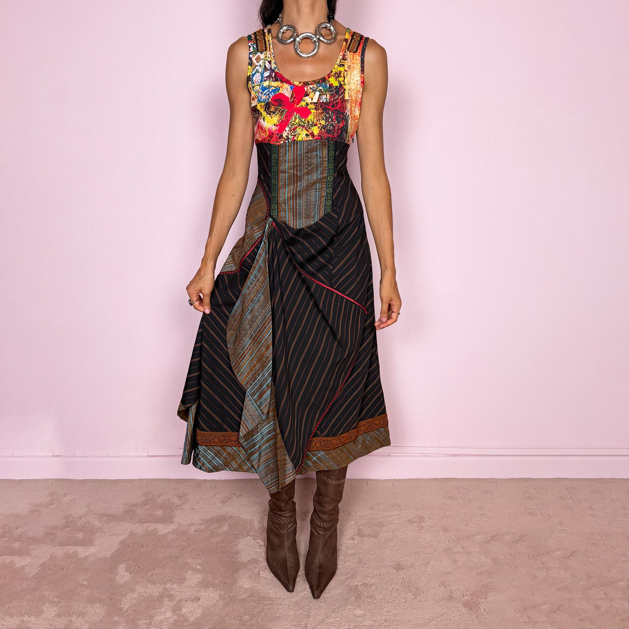 Vintage 2000s midi dress designed with a dramatic medieval-inspired avant-garde silhouette. It features a graphic bust panel with vivid abstract artwork, a fitted corset-effect waist with striped and patterned panels, a side zip closure, and a flowing asymmetric skirt with mixed striped fabrics, contrast trims, and layered draped sections for sculptural movement. Only the bust area has stretch, while the rest of the dress  A rare fantasy statement piece with a theatrical baroque feel.