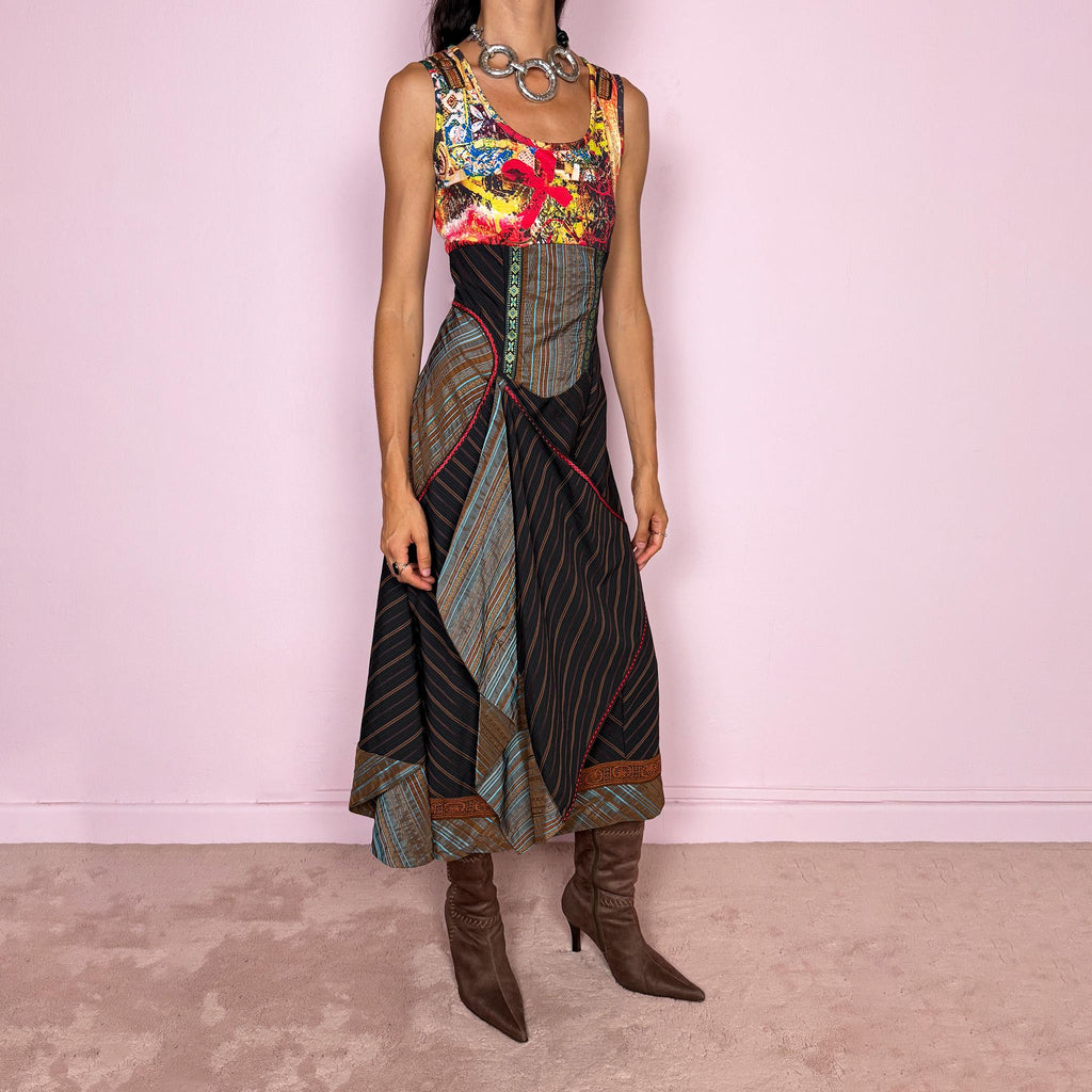 Vintage 2000s midi dress designed with a dramatic medieval-inspired avant-garde silhouette. It features a graphic bust panel with vivid abstract artwork, a fitted corset-effect waist with striped and patterned panels, a side zip closure, and a flowing asymmetric skirt with mixed striped fabrics, contrast trims, and layered draped sections for sculptural movement. Only the bust area has stretch, while the rest of the dress  A rare fantasy statement piece with a theatrical baroque feel.