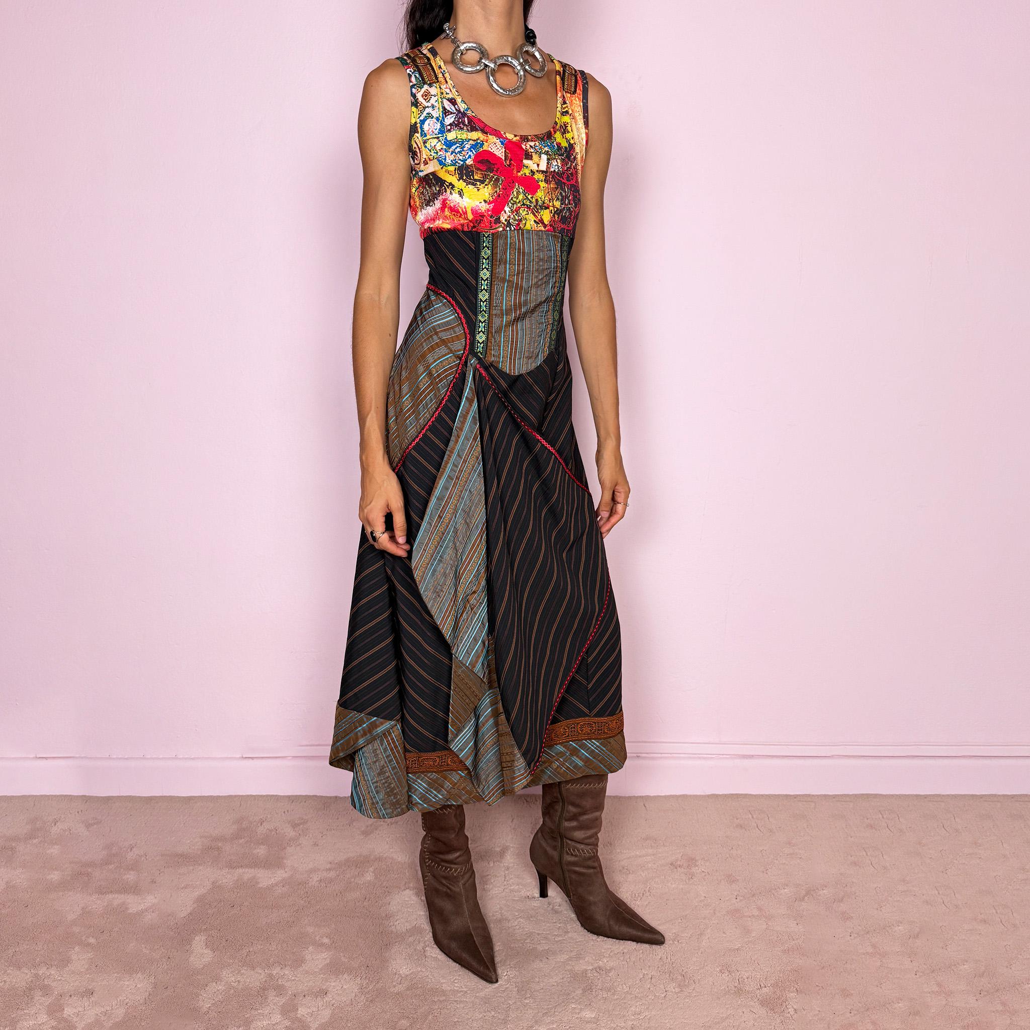Vintage 2000s midi dress designed with a dramatic medieval-inspired avant-garde silhouette. It features a graphic bust panel with vivid abstract artwork, a fitted corset-effect waist with striped and patterned panels, a side zip closure, and a flowing asymmetric skirt with mixed striped fabrics, contrast trims, and layered draped sections for sculptural movement. Only the bust area has stretch, while the rest of the dress  A rare fantasy statement piece with a theatrical baroque feel.
