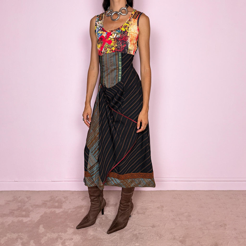 Vintage 2000s midi dress designed with a dramatic medieval-inspired avant-garde silhouette. It features a graphic bust panel with vivid abstract artwork, a fitted corset-effect waist with striped and patterned panels, a side zip closure, and a flowing asymmetric skirt with mixed striped fabrics, contrast trims, and layered draped sections for sculptural movement. Only the bust area has stretch, while the rest of the dress  A rare fantasy statement piece with a theatrical baroque feel.