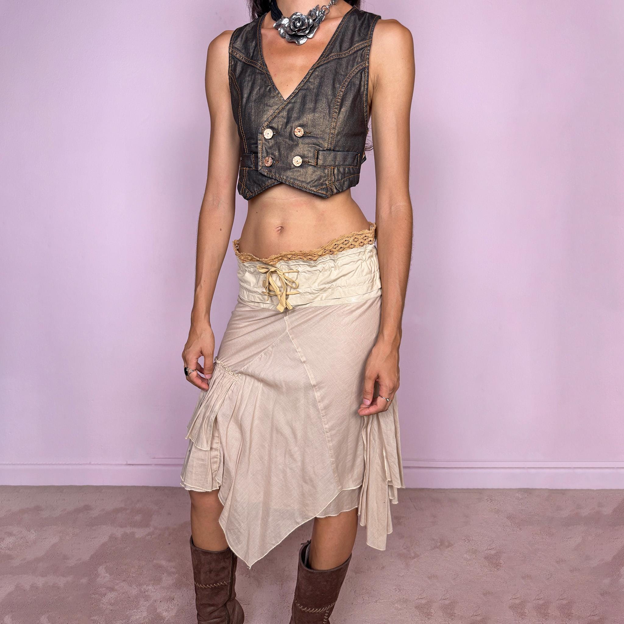 Vintage 2000s midi skirt, crafted from 100% cotton in a soft beige tone with a romantic low-rise silhouette and adjustable tie-front waist. Designed with a wide structured waistband, lace-up front detail, crochet-style trim along the top edge, and an asymmetric layered skirt with panel construction. A delicate bohemian Y2K piece with a deconstructed fairy summer feel. Very good vintage condition, with one small faint discoloured mark on the waistband, as shown in the last picture.