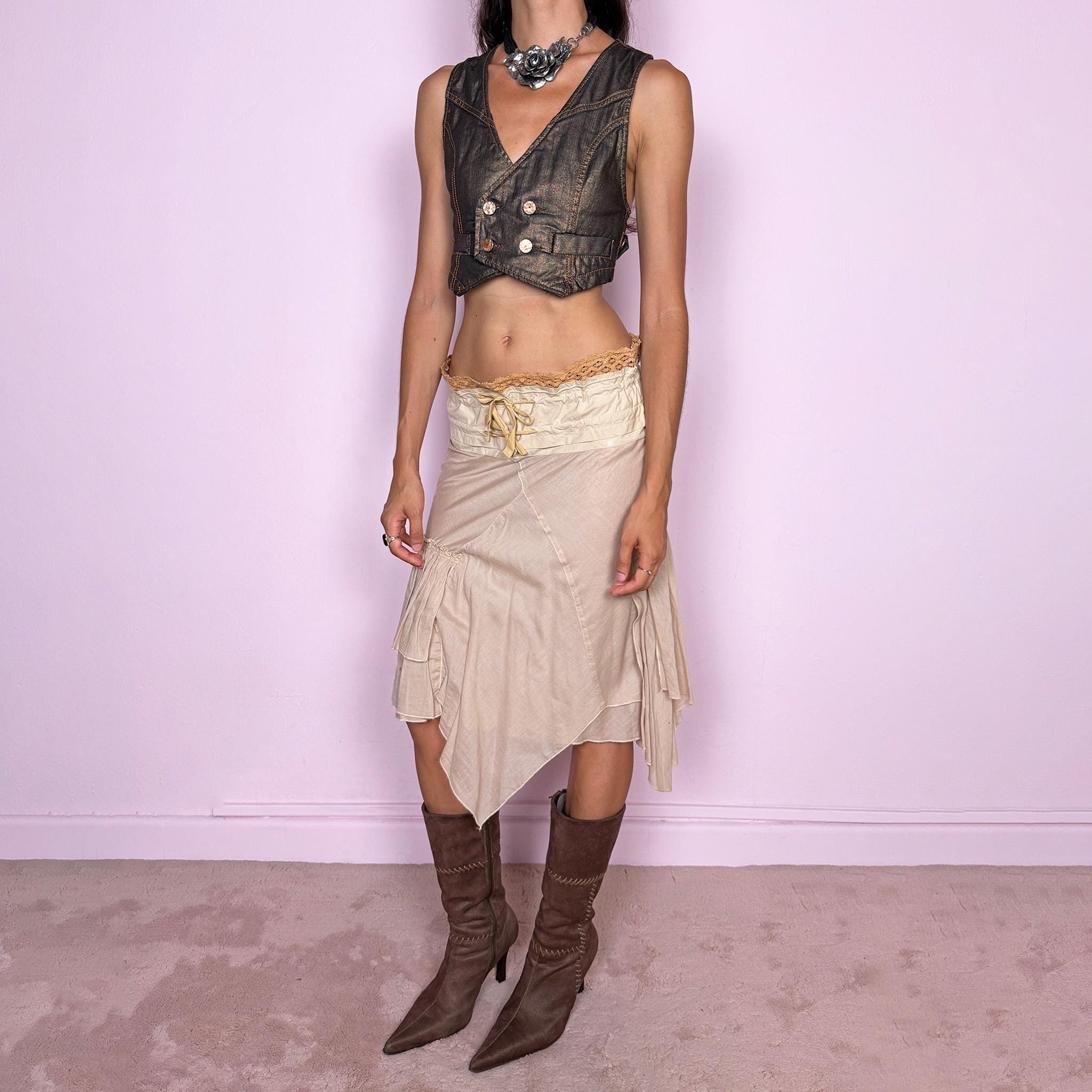 Vintage 2000s midi skirt, crafted from 100% cotton in a soft beige tone with a romantic low-rise silhouette and adjustable tie-front waist. Designed with a wide structured waistband, lace-up front detail, crochet-style trim along the top edge, and an asymmetric layered skirt with panel construction. A delicate bohemian Y2K piece with a deconstructed fairy summer feel. Very good vintage condition, with one small faint discoloured mark on the waistband, as shown in the last picture.