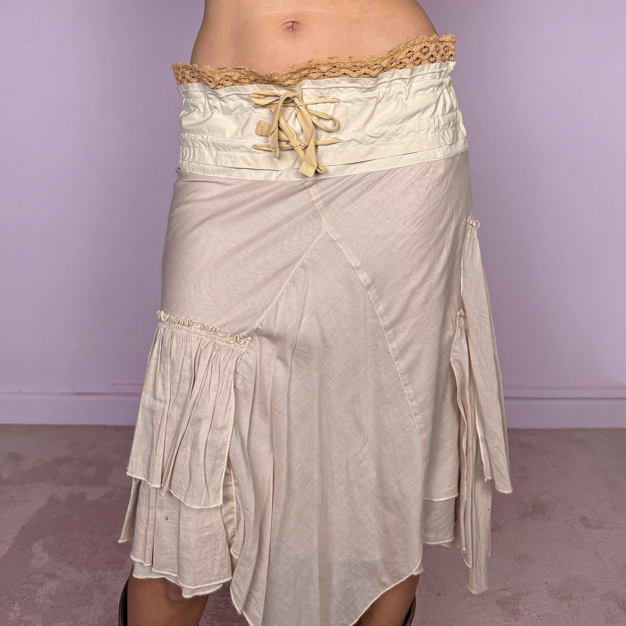 Vintage 2000s midi skirt, crafted from 100% cotton in a soft beige tone with a romantic low-rise silhouette and adjustable tie-front waist. Designed with a wide structured waistband, lace-up front detail, crochet-style trim along the top edge, and an asymmetric layered skirt with panel construction. A delicate bohemian Y2K piece with a deconstructed fairy summer feel. Very good vintage condition, with one small faint discoloured mark on the waistband, as shown in the last picture.