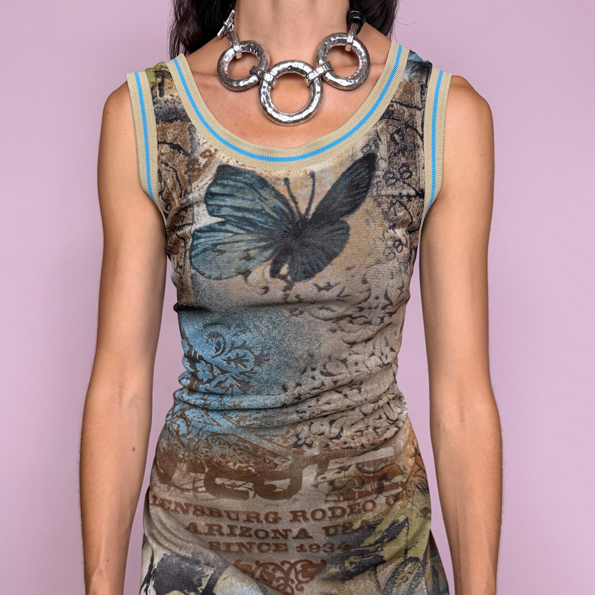 Vintage 2000s fitted sleeveless midi dress in lightweight stretch mesh with matching mesh lining for a softly sheer layered effect. Features blue, green and brown butterfly graphics, faded architectural motifs, postcard-style typography and contrast trim, with a visual Y2K art-to-wear feel for maximalist editorial styling. Made in France by a French brand. Excellent vintage condition.