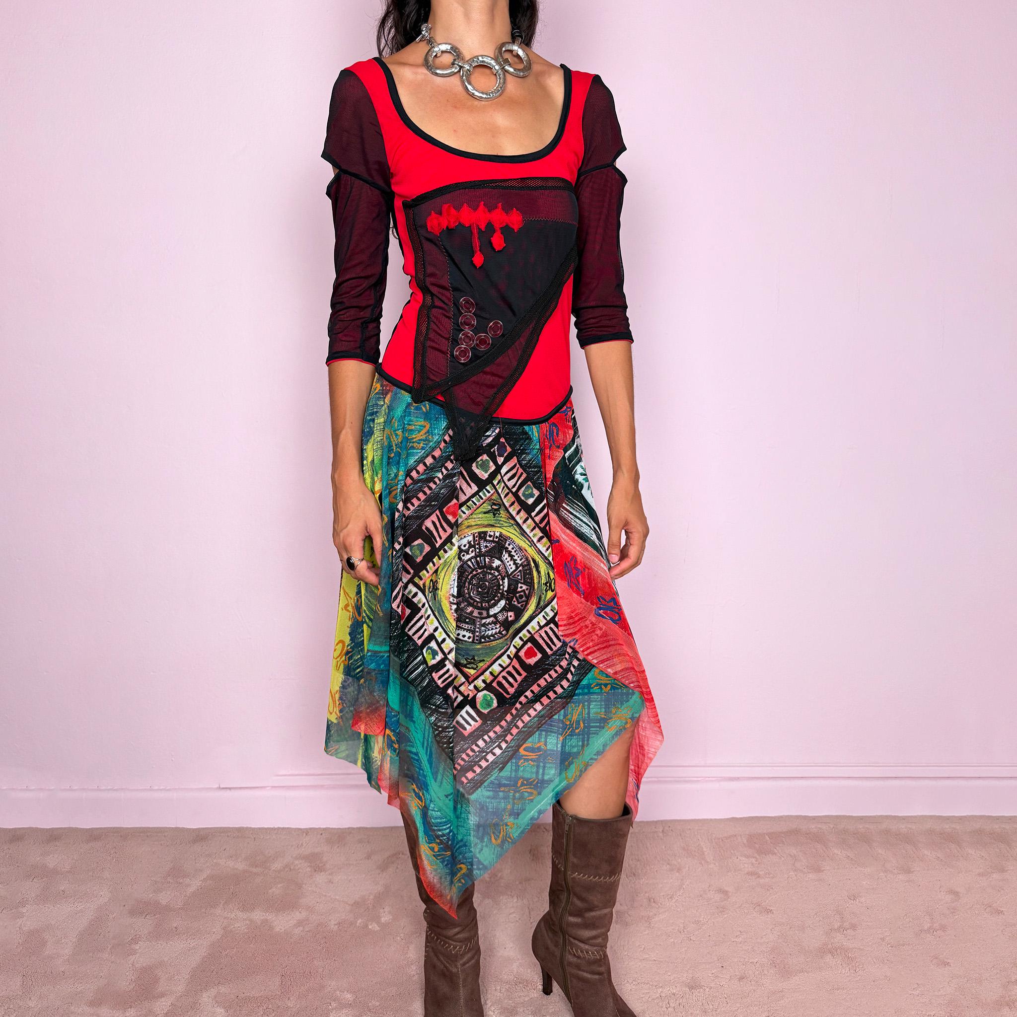 Vintage 2000s Save The Queen dress crafted from a stretchy semi-sheer mesh fabric with a bold graphic design. Designed in a fitted statement silhouette, it features a vivid red and black upper body with half sleeves and layered asymmetric panels that fall into a striking mixed-print skirt with abstract, geometric and hand-drawn motifs in red, turquoise, yellow, black and white tones. A highly visual Italian Y2K piece with an art-to-wear feel, perfect for a dramatic maximalist 2000s look.