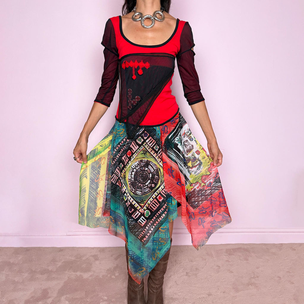 Vintage 2000s Save The Queen dress crafted from a stretchy semi-sheer mesh fabric with a bold graphic design. Designed in a fitted statement silhouette, it features a vivid red and black upper body with half sleeves and layered asymmetric panels that fall into a striking mixed-print skirt with abstract, geometric and hand-drawn motifs in red, turquoise, yellow, black and white tones. A highly visual Italian Y2K piece with an art-to-wear feel, perfect for a dramatic maximalist 2000s look.
