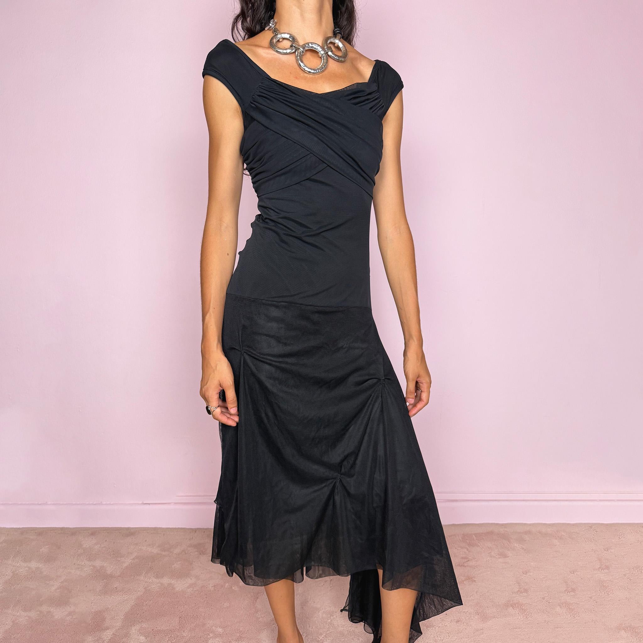 Vintage 2000s Save The Queen black midi dress with semi-sheer mesh layering and a sculptural asymmetric silhouette. It features a softly draped off-shoulder neckline, short cap sleeves, a fitted stretch body with diagonal ruching through the bust and waist, and an asymmetric layered skirt with sheer mesh panels, gathered details, and a long cascading side drape for dramatic movement. A rare Italian Y2K statement piece with a dark romantic evening feel, perfect for elegant parties and occasions.