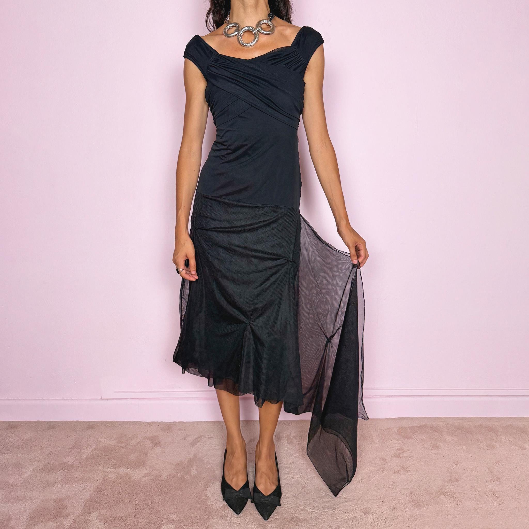 Vintage 2000s Save The Queen black midi dress with semi-sheer mesh layering and a sculptural asymmetric silhouette. It features a softly draped off-shoulder neckline, short cap sleeves, a fitted stretch body with diagonal ruching through the bust and waist, and an asymmetric layered skirt with sheer mesh panels, gathered details, and a long cascading side drape for dramatic movement. A rare Italian Y2K statement piece with a dark romantic evening feel, perfect for elegant parties and occasions.
