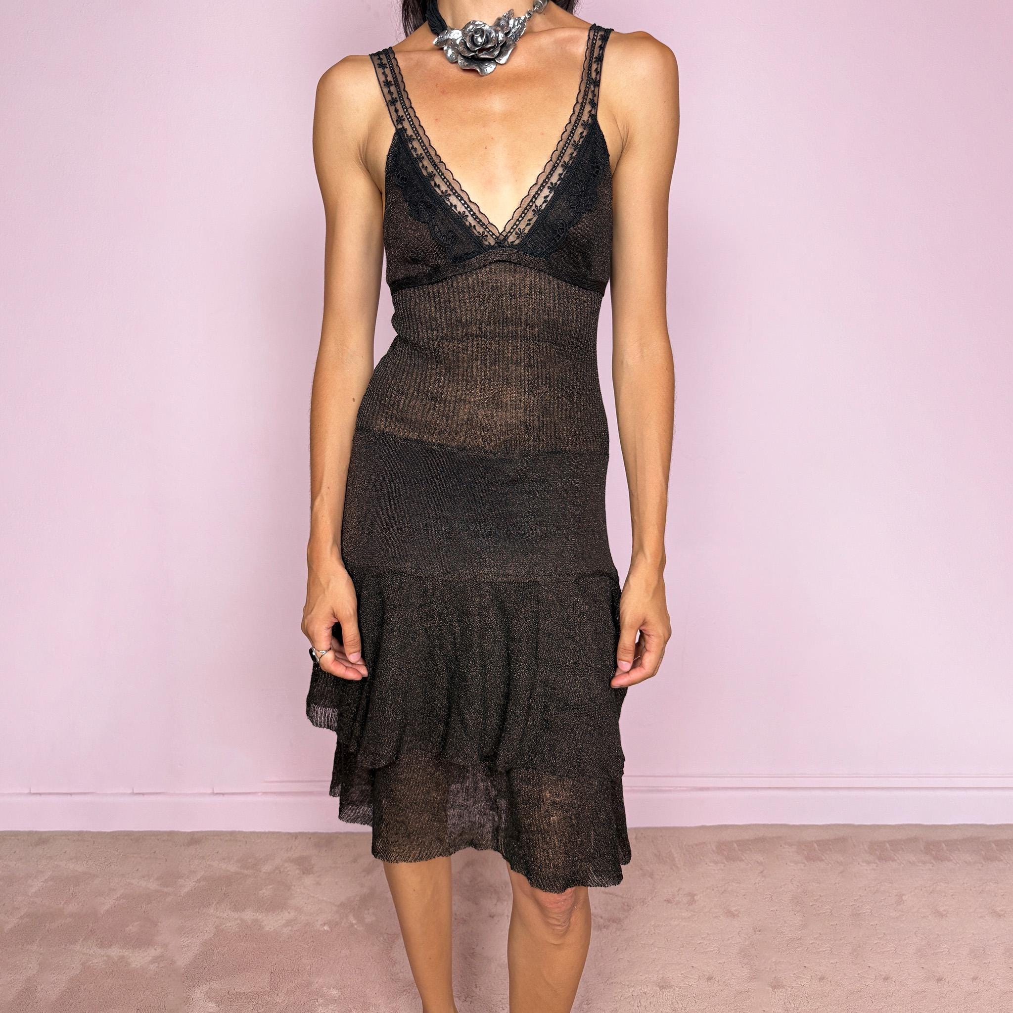 Vintage 2000s midi dress in a dark brown tone with a subtle bronze shimmer and semi-sheer textured finish. It features a delicate lingerie-inspired V neckline with black lace trim, straps, a fitted stretch body, tie-back detail, and a softly flared skirt with layered ruffle panels. A sensual Y2K piece with a moody feminine feel, ideal for an elevated gothic fairy evening look. Made in Italy by Liu Jo from a stretchy 78% linen and 22% metallic fibre blend. Excellent vintage condition.