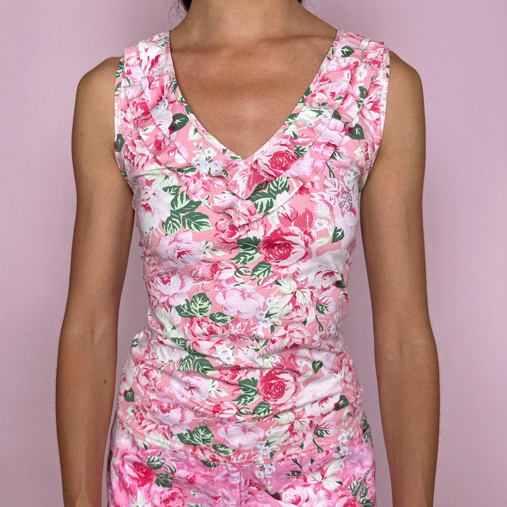 Vintage 2000s Blumarine Beachwear top crafted from a stretchy swimwear-like fabric with a fitted silhouette and soft pink floral print. Designed with a V neckline, layered ruffle trim, sleeveless cut, and a small rhinestone logo detail at the front. A romantic summer Y2K Italian designer piece, ideal for beachwear styling. Size and composition labels are missing, so the exact fabric and tagged size are unknown.