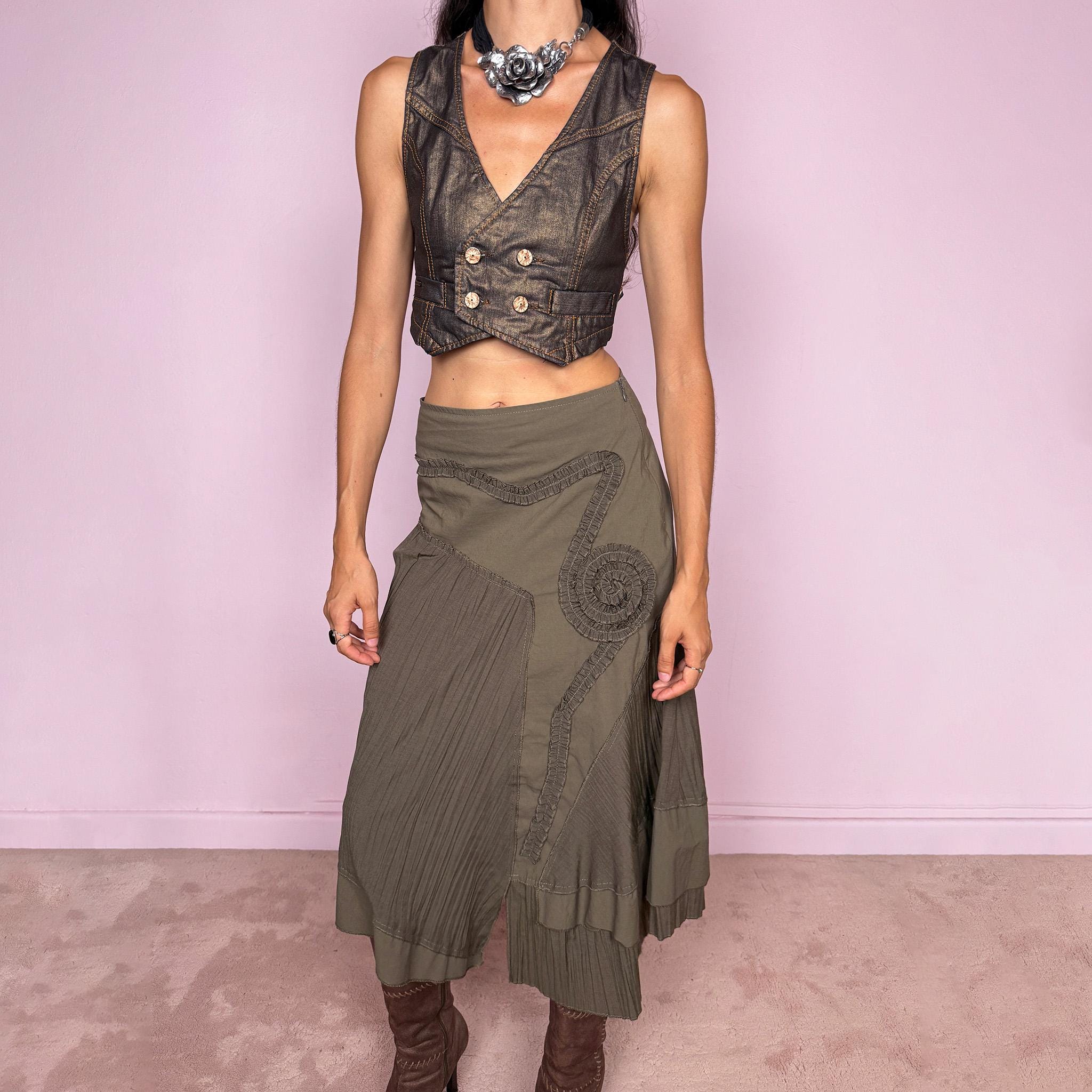 Vintage 2000s dark khaki asymmetric midi skirt designed with an irregular layered silhouette combining pleated panels, curved seam construction, sculptural ruffled appliqué detailing, a side zip closure, and a layered hem. Ideal for unique earthy fairy styling. Can be worn high-waisted for size S or lower on the waist for sizes XS–XXS. Made in France by a French brand from a non-stretch blend of 61% viscose and 39% polyamide. Great vintage condition.