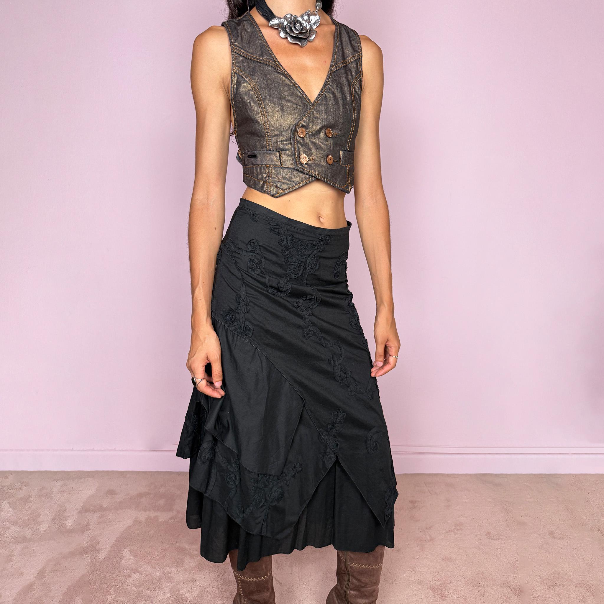 Vintage 2000s black midi skirt crafted from 100% cotton with layered asymmetric panels and tonal floral embroidery appliqué. Features a back zip closure and no stretch. Ideal for bohemian, dark fairy, or summer styling. Can be worn high-waisted for size S or slightly lower on the waist for sizes XS–XXS. Made in France by a French brand and fully lined in 100% polyester. Excellent vintage condition.