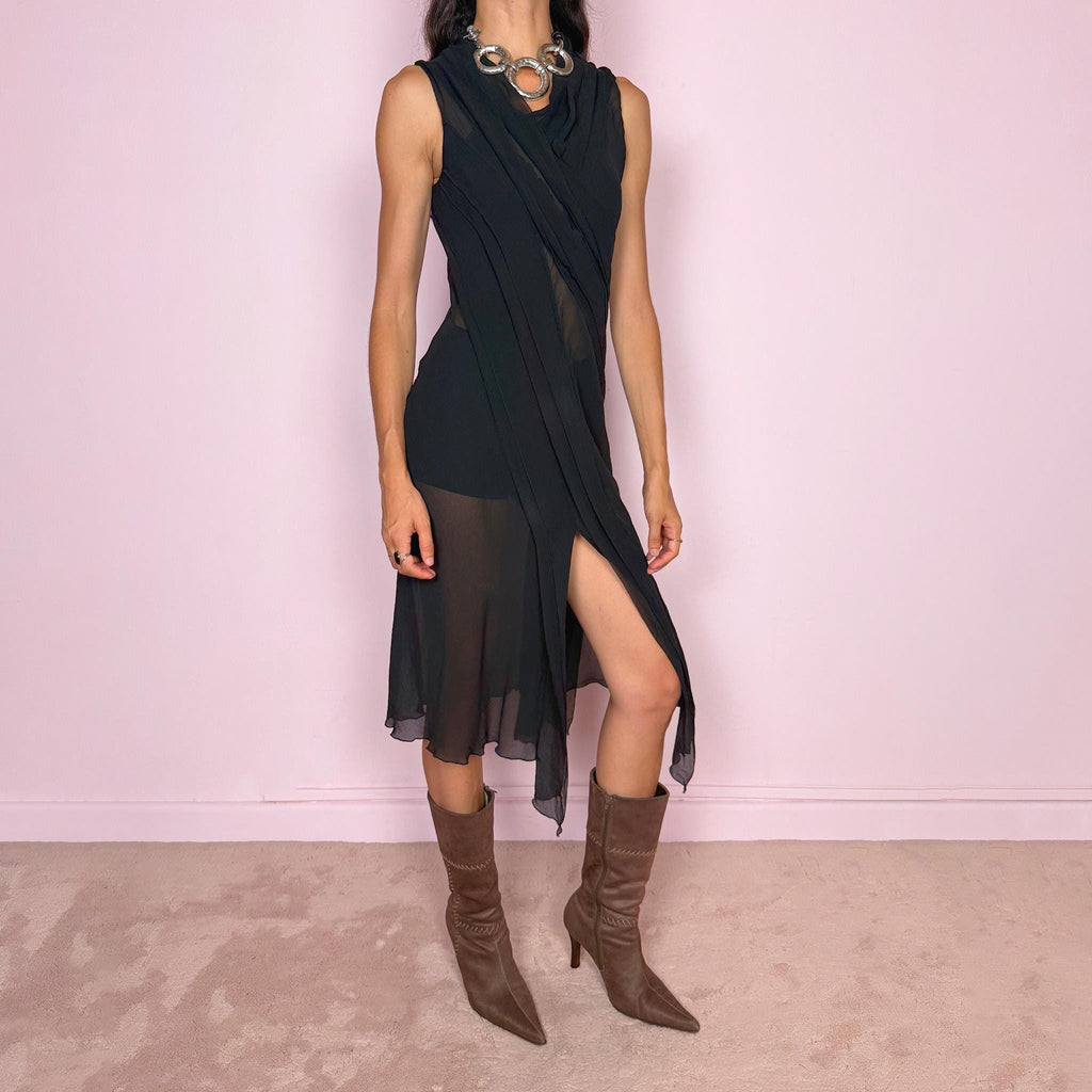 Vintage 2000s black semi-sheer midi dress with a fluid sleeveless silhouette, asymmetric draped panel construction, and a front opening that creates soft movement through the hem. The layered fabric falls in long sculptural lines across the body, giving the dress an elegant dark avant-garde feel. Brand, size, and composition labels are missing; the fabric feels like silk, but the exact composition cannot be confirmed. Great vintage condition.