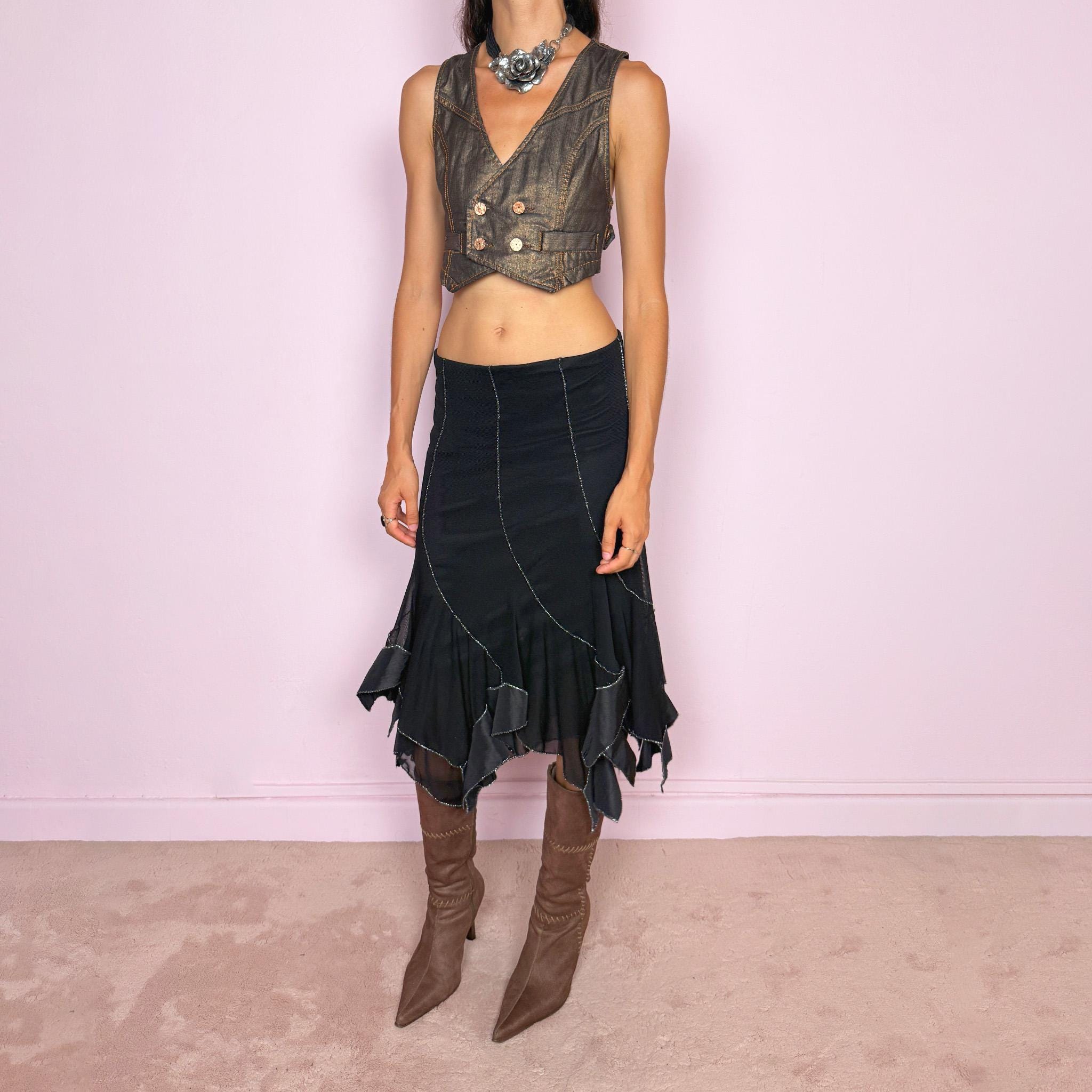 Vintage 2000s black mesh midi skirt, featuring a fluid asymmetric layered construction with sheer panels and an irregular handkerchief hem. Finished with contrasting metallic thread along the curved seams and edges, creating a subtle shimmering effect throughout. Stretchy with an elasticated waist, ideal for statement evening looks. Can be worn mid- to low-rise for size S. Made in Italy from 95% viscose. Excellent vintage condition.