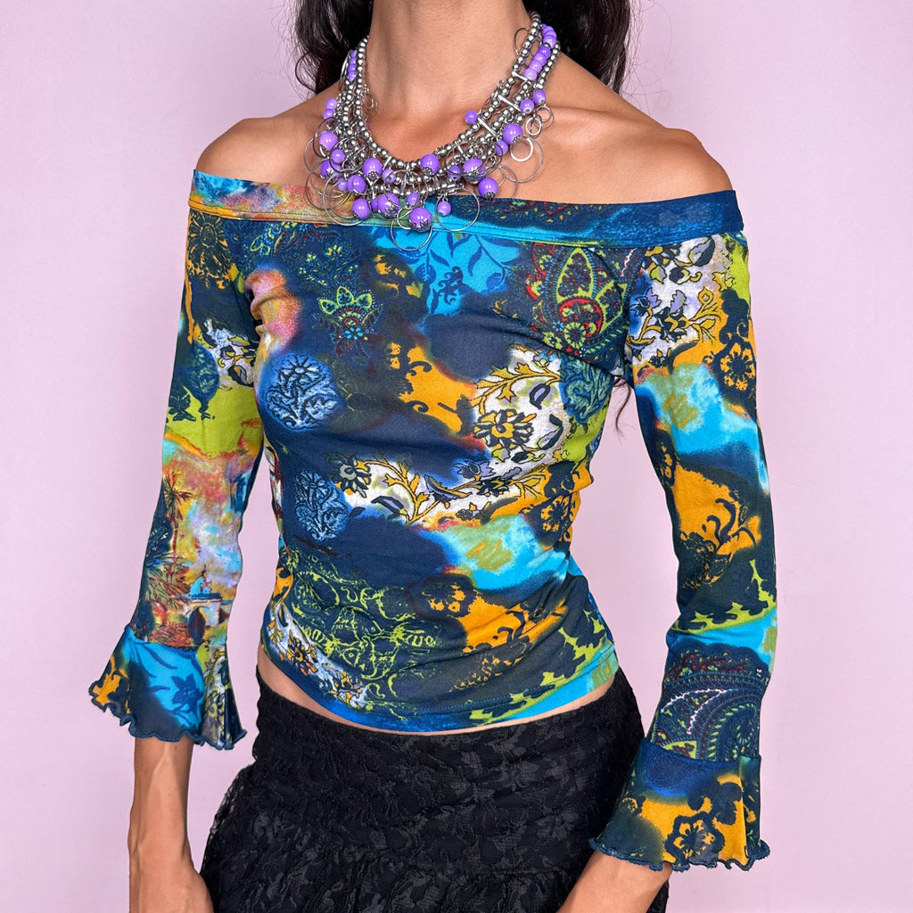Vintage 2000s off-shoulder mesh top featuring a fitted, semi-sheer silhouette with a wide bateau neckline and flared three-quarter sleeves. Finished in a vivid mixed graphic print combining deep blue, turquoise, lime, yellow, and ornamental motifs for a maximalist bohemian Y2K look. Made in Italy by an Italian brand from 66% polyester and 34% polyamide. Excellent vintage condition.