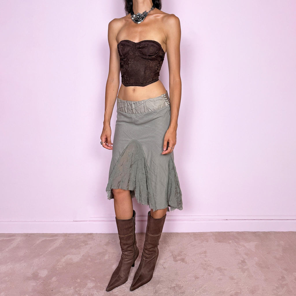 Vintage 2000s khaki green midi skirt, made in Italy and crafted from a lightweight 60% cotton and 40% silk blend. Features an asymmetric hem, delicate semi-sheer godet-style inserts, raw-edged detailing, and round bead-like buttons for an ethereal, fairy-like deconstructed feel. Finished with a side zip closure and no stretch. Can be worn mid- to low-rise for sizes XS–S. From an Italian brand. Excellent vintage condition.