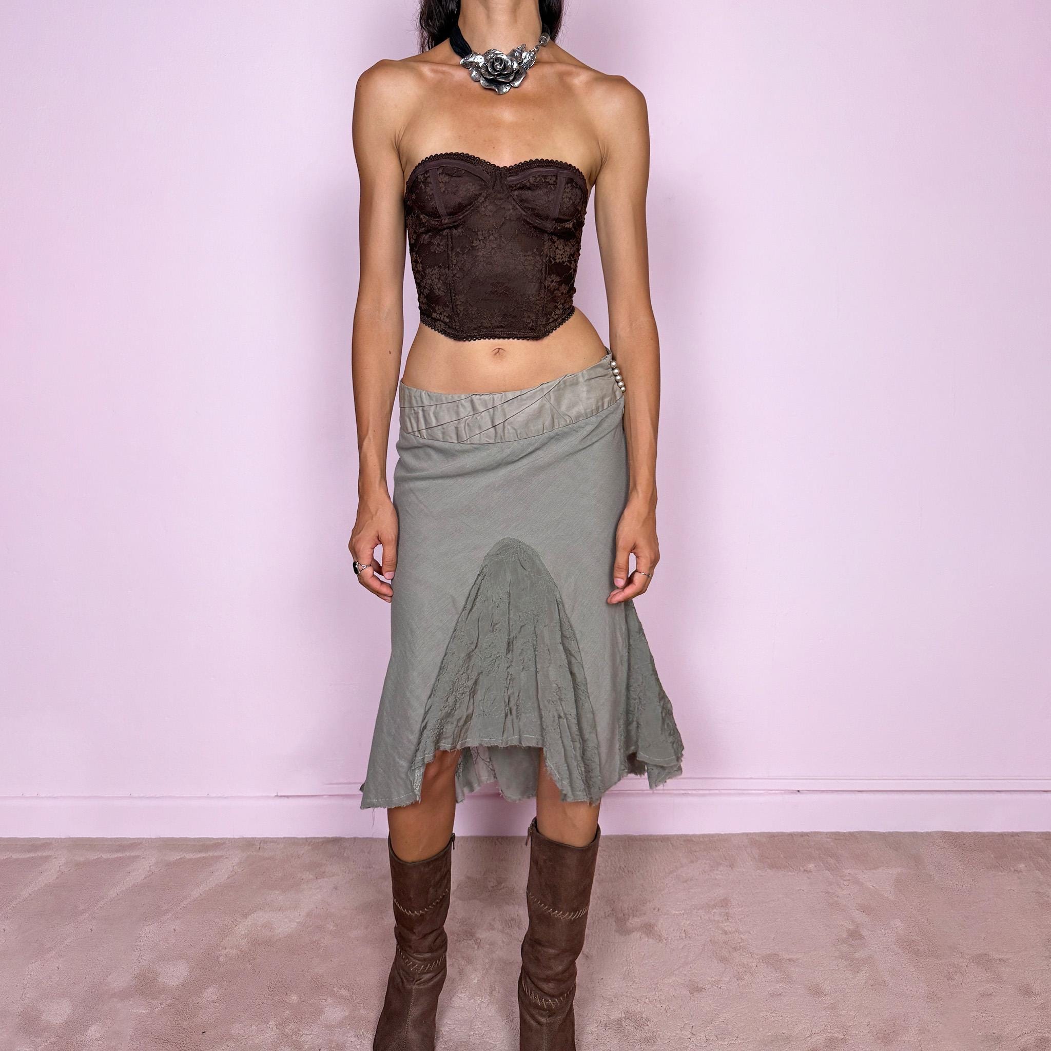 Vintage 2000s khaki green midi skirt, made in Italy and crafted from a lightweight 60% cotton and 40% silk blend. Features an asymmetric hem, delicate semi-sheer godet-style inserts, raw-edged detailing, and round bead-like buttons for an ethereal, fairy-like deconstructed feel. Finished with a side zip closure and no stretch. Can be worn mid- to low-rise for sizes XS–S. From an Italian brand. Excellent vintage condition.