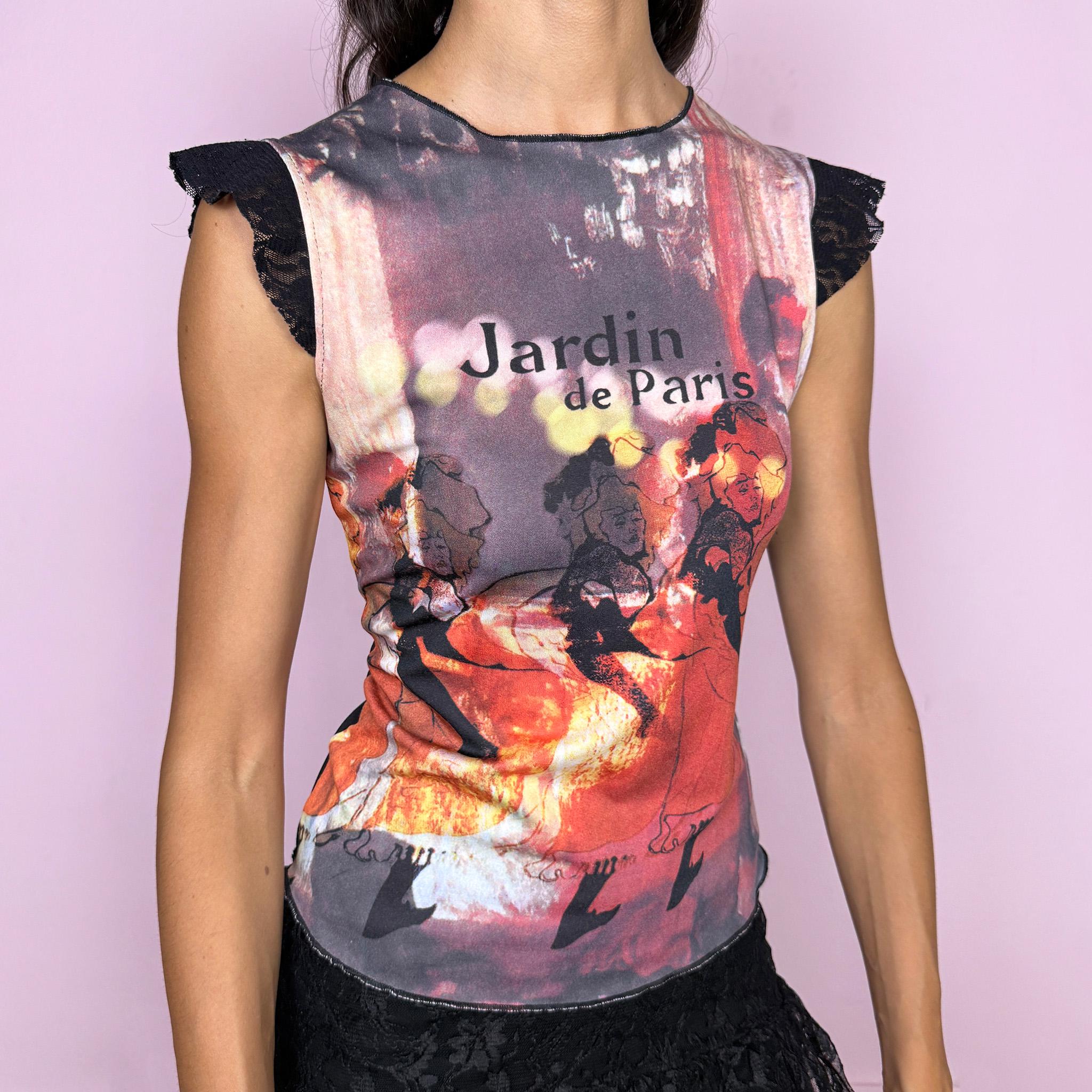 Vintage 2000s fitted graphic top featuring a striking Paris-inspired art print in red, burgundy, black, and warm orange tones. Designed with a feminine “Jardin de Paris” graphic combining illustrated figures and atmospheric photographic imagery, and finished with delicate black lace cap-sleeve inserts. Made from a stretchy polyester, elastane, and nylon blend. A distinctive Y2K art-print piece with a romantic Parisian feel. Excellent vintage condition.