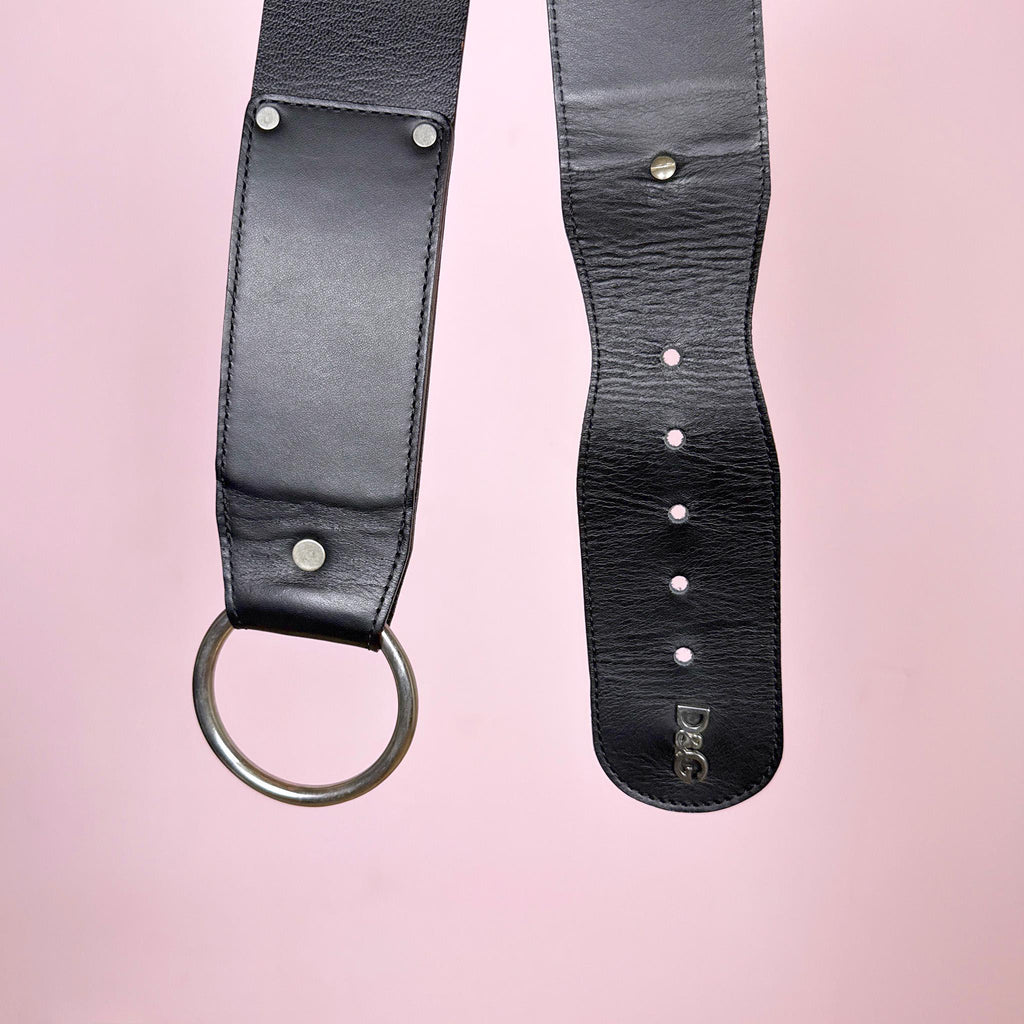 Vintage 2000s D&G Dolce & Gabbana belt, made in Italy from genuine black leather. Designed with an extra-wide statement silhouette, a large silver-tone metal O-ring buckle, and a metal D&G logo at the end. The adjustable fastening allows it to be styled at the waist or lower on the hips. Marked size 90, which generally refers to approximately 90 cm from the buckle to the central fastening hole. A striking and highly versatile Italian designer Y2K accessory. Great vintage condition.