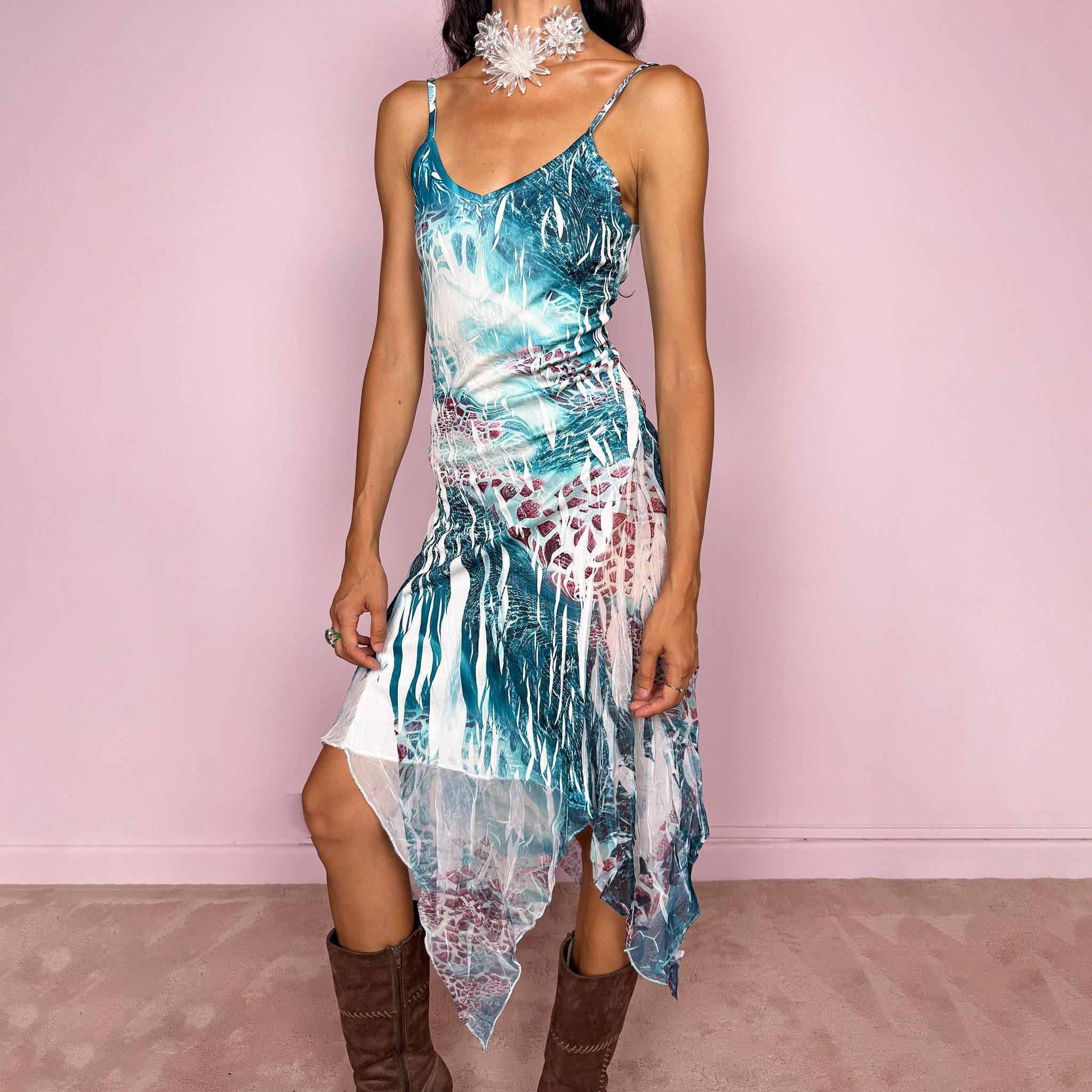 Vintage 2000s slip dress with thin straps and a fitted, body-skimming silhouette, featuring an abstract bohemian print in teal, white, and burgundy over a crinkle-textured base. Crafted from lightweight, semi-sheer fabric with a dramatic asymmetric handkerchief hem that creates fluid movement and a deconstructed, dreamy maximalist Y2K feel. Made in France from 100% polyester. Excellent vintage condition.