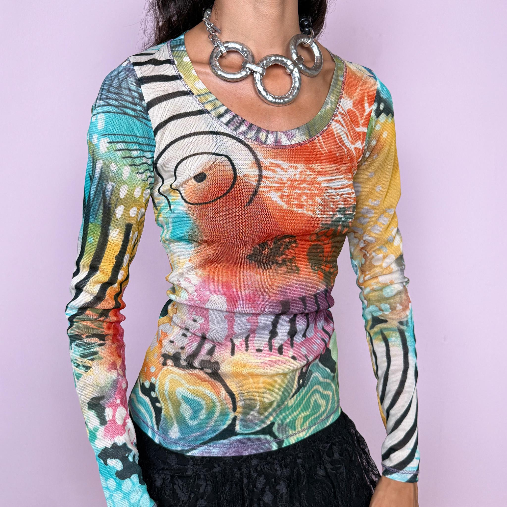 Vintage 2000s long-sleeve mesh top featuring a vibrant abstract graphic print mixing turquoise, orange, yellow, pink, and green with contrasting organic, striped, and painterly motifs. Designed with a fitted silhouette, scoop neckline, and semi-sheer lightweight mesh construction. Stretchy fabric creates a close, second-skin fit. A strong maximalist Y2K piece with an art-print feel. Made in France by a French brand from 100% polyester. Excellent vintage condition.