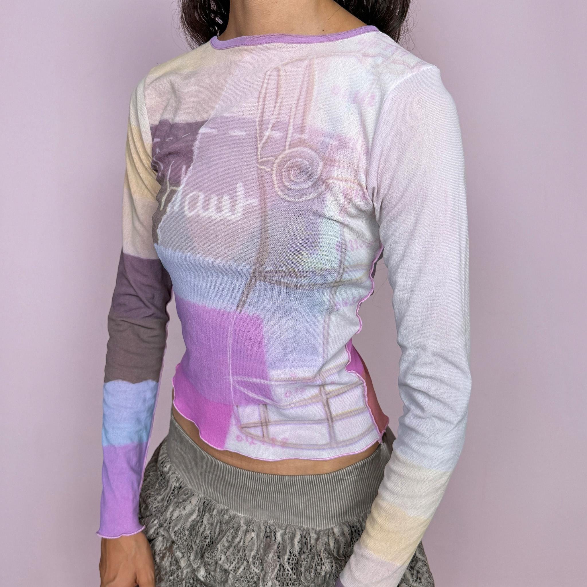 Vintage 2000s Cop Copine long-sleeve top featuring a soft pastel graphic print in lilac, cream, and pink tones. Designed with a fitted silhouette, round neckline, and contrasting color-blocked sleeves. Soft and stretchy with a lightweight, second-skin feel. A playful pastel Y2K piece by a French brand with a dreamy graphic-art aesthetic. The composition label is missing, so the exact fabric is unknown. Excellent vintage condition.
