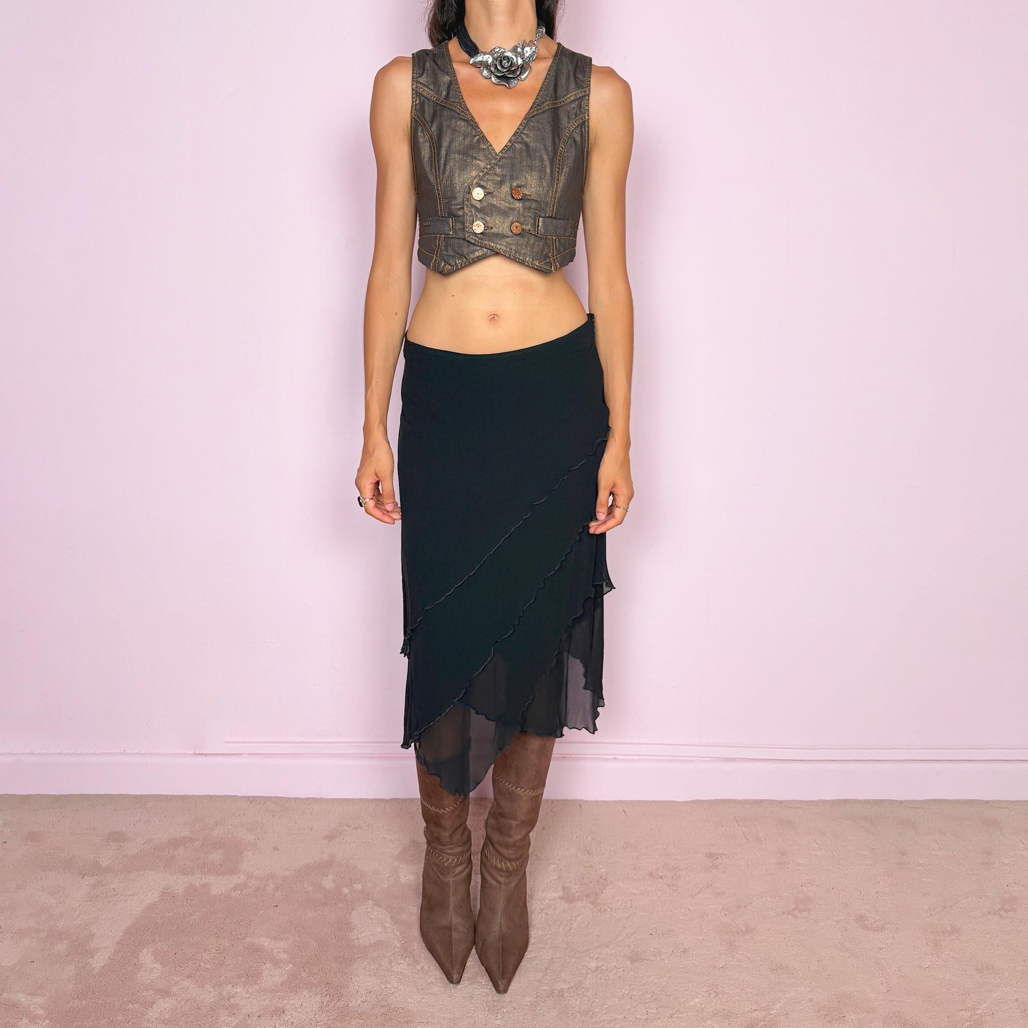 Vintage 2000s black asymmetric midi skirt crafted from 100% silk, featuring a layered construction with overlapping diagonal panels and delicate lettuce-edge finishing throughout. Features a side zip closure and no stretch. An elegant, dark minimalist avant-garde silhouette with beautiful fluid movement. Can be worn mid-rise for size M or lower-rise for size S. By German fashion brand Marc Cain. 100% silk outer with 100% nylon lining. Excellent vintage condition.