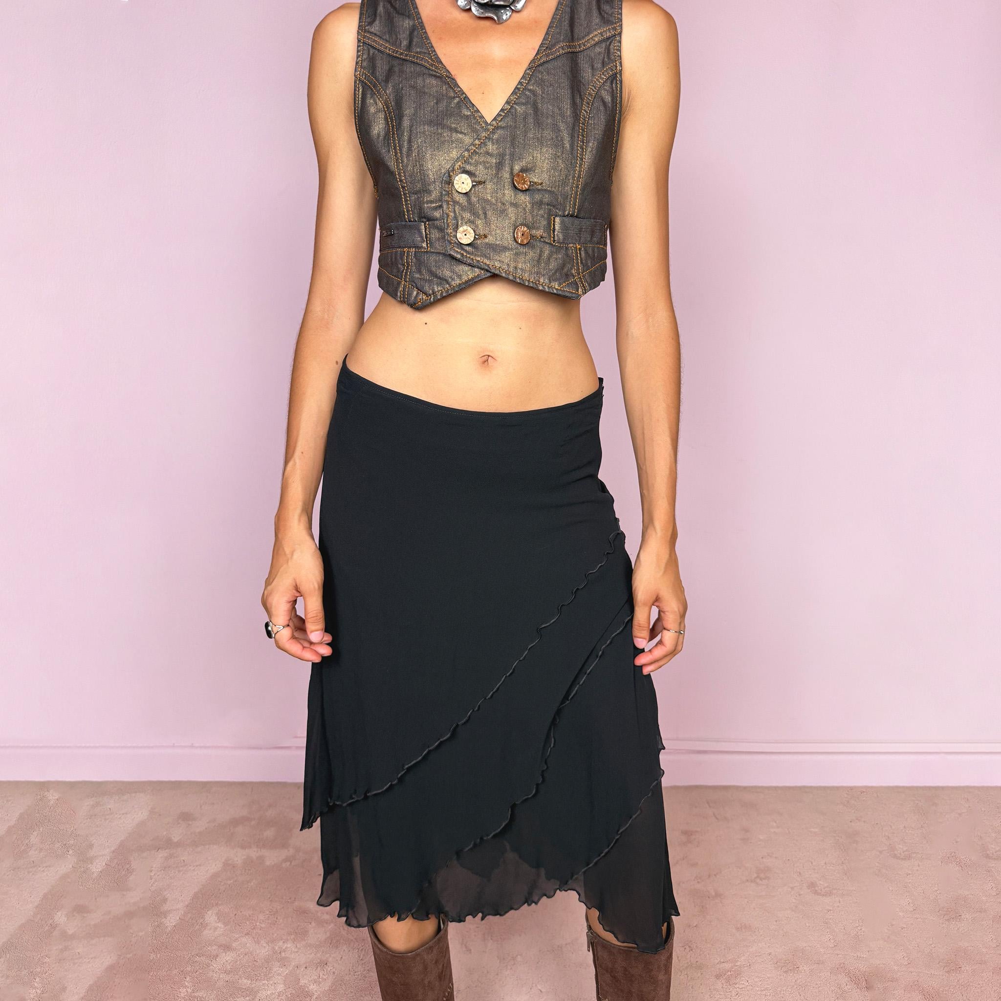 Vintage 2000s black asymmetric midi skirt crafted from 100% silk, featuring a layered construction with overlapping diagonal panels and delicate lettuce-edge finishing throughout. Features a side zip closure and no stretch. An elegant, dark minimalist avant-garde silhouette with beautiful fluid movement. Can be worn mid-rise for size M or lower-rise for size S. By German fashion brand Marc Cain. 100% silk outer with 100% nylon lining. Excellent vintage condition.