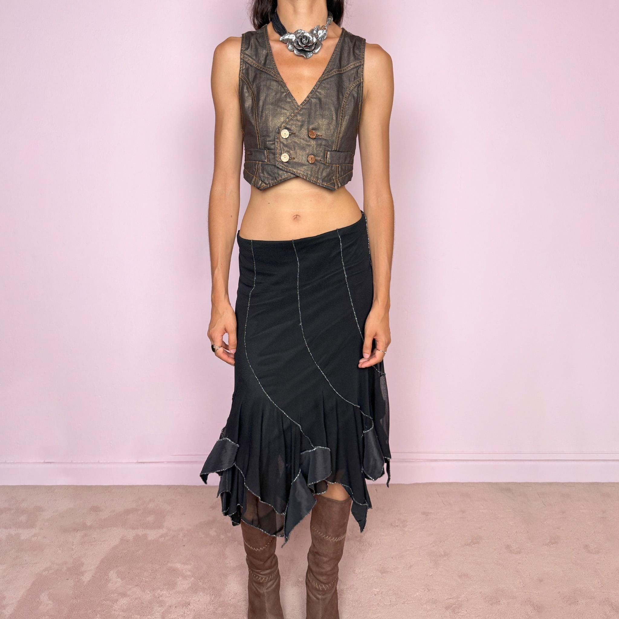 Vintage 2000s black mesh midi skirt, featuring a fluid asymmetric layered construction with sheer panels and an irregular handkerchief hem. Finished with contrasting metallic thread along the curved seams and edges, creating a subtle shimmering effect throughout. Stretchy with an elasticated waist, ideal for statement evening looks. Can be worn mid- to low-rise for size S. Made in Italy from 95% viscose. Excellent vintage condition.