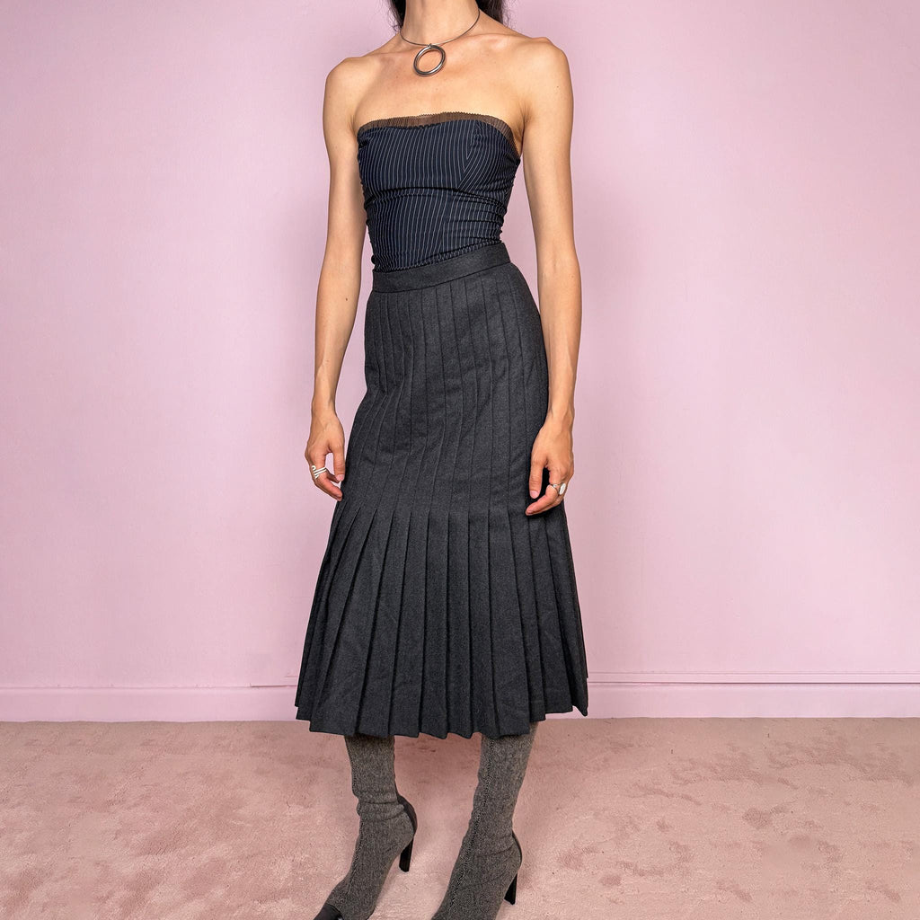 Vintage 90s dark gray midi skirt crafted from a 90% wool and 10% cashmere blend with a full 100% viscose lining. Features all-over pleating, thick non-stretch fabric, and a side zip closure. Fits mid- to high-waisted for size S. A beautifully constructed cold-weather piece combining classic tailoring with an understated avant-garde, minimalist edge. Made by a German brand. Excellent vintage condition.