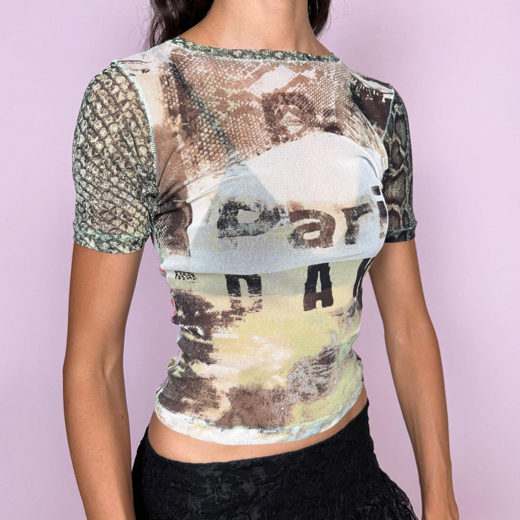 Vintage 2000s Roberto Cavalli Freedom mesh top crafted from semi-sheer, stretchy mesh with a fitted silhouette and short sleeves. It features an eclectic mixed print that contrasts earthy photographic and snakeskin-inspired graphics at the front with a vibrant retro floral print across the back. Lightweight, sheer, and body-skimming, with a distinctly maximalist Y2K Cavalli feel. Made in Italy from 100% polyamide. Excellent vintage condition.