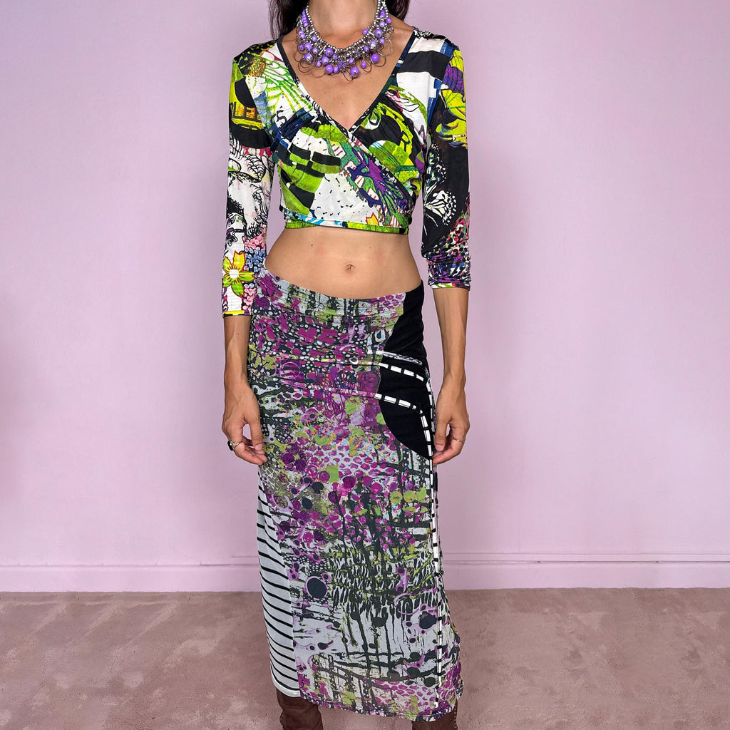Vintage 2000s two-piece set featuring a fitted wrap-style crop top and matching printed midi skirt. The top has three-quarter sleeves, a deep V-neckline, and an adjustable tie-back closure. The matching skirt is made from stretchy mesh with an elasticated waist and abstract graphic print, featuring ruched detailing through the hip and decorative trailing straps for an asymmetric, deconstructed finish. It can be worn mid- to low-rise.
