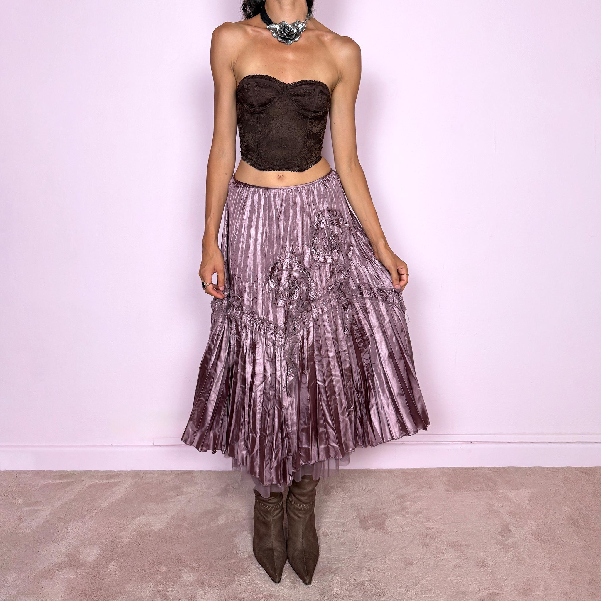 Vintage 2000s dusty mauve metallic midi skirt featuring intricate all-over pleating with a fluid iridescent sheen, sculptural floral appliqué details, and sheer tulle fabric peeking from underneath the hem. Ideal for parties or dreamy, romantic elevated outfits. Can be worn high-waisted for size S or lower on the waist for size XS. From a French brand. Crafted from 100% polyester with no stretch and finished with a side zip closure. Excellent vintage condition.