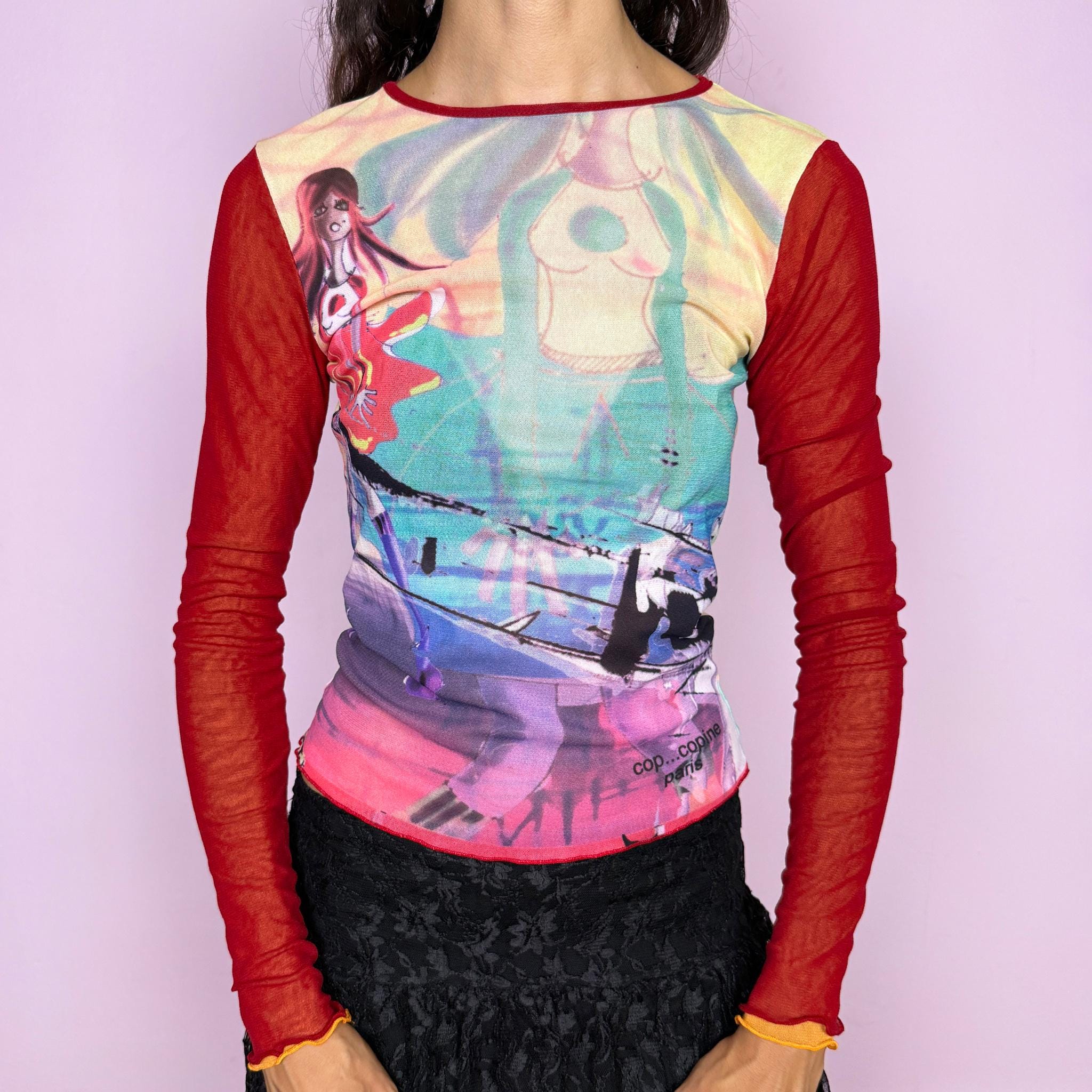 Vintage 2000s Cop Copine graphic mesh top featuring a vibrant multicolored illustrated print with female figures and abstract graphics across the body, contrasted with sheer red mesh long sleeves and delicate lettuce-edge finishes. The fitted second-skin silhouette and semi-sheer construction give it a distinctive Y2K French maximalist, avant-garde art-to-wear feel. Made in France from a stretchy polyamide and polyester blend. Excellent vintage condition.