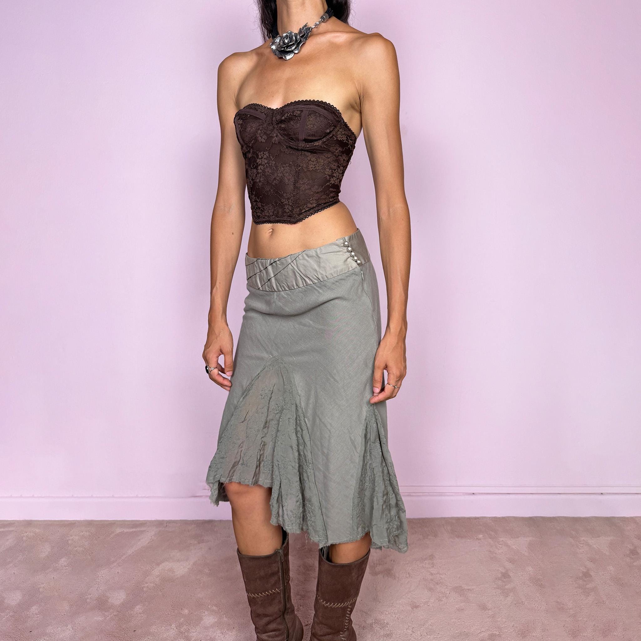 Vintage 2000s khaki green midi skirt, made in Italy and crafted from a lightweight 60% cotton and 40% silk blend. Features an asymmetric hem, delicate semi-sheer godet-style inserts, raw-edged detailing, and round bead-like buttons for an ethereal, fairy-like deconstructed feel. Finished with a side zip closure and no stretch. Can be worn mid- to low-rise for sizes XS–S. From an Italian brand. Excellent vintage condition.
