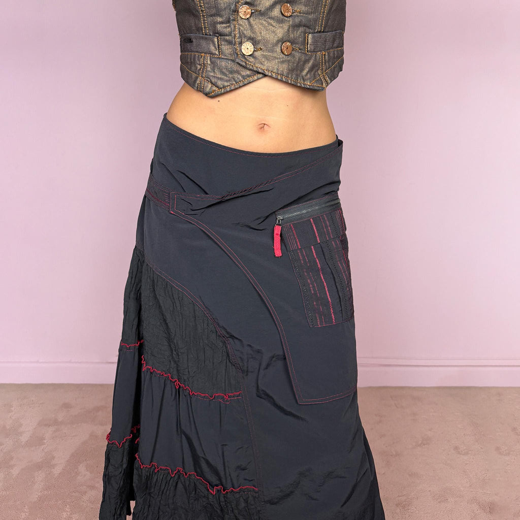Vintage 2000s black deconstructed midi skirt with a structured, non-stretch feel. Features asymmetric paneled construction, contrasting red topstitching, a utility-inspired zip pocket, and layered crinkled fabric inserts. Finished with a back zip closure. A distinctive dark avant-garde piece with a dystopian, futuristic Y2K feel. Can be worn high-waisted for size M or mid- to lower-rise for sizes S–XS. Made in France by a French brand.