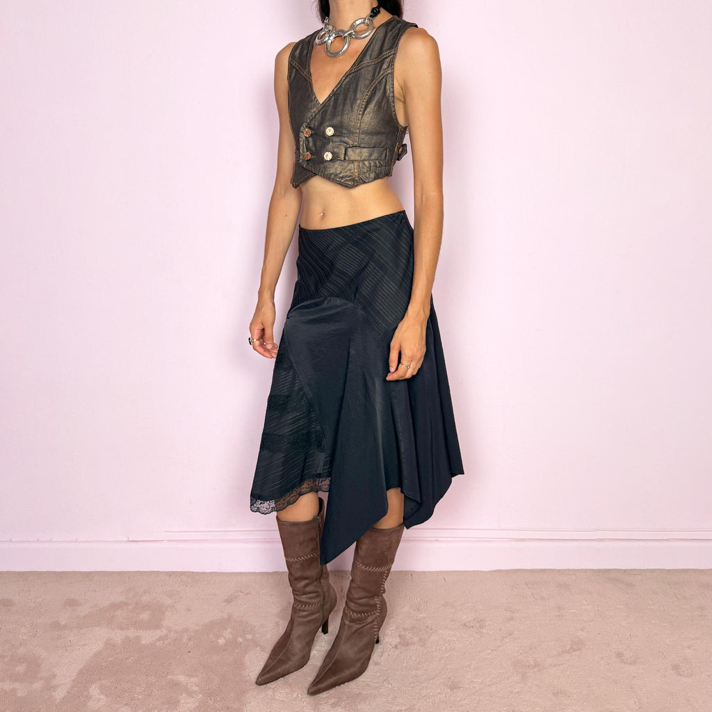 Vintage 2000s black asymmetric midi skirt featuring a deconstructed patchwork construction that combines fine pinstripe panels with contrasting fabric sections and subtle lace-trim detailing. Designed with a dramatic irregular handkerchief-style hem and a dark avant-garde Y2K silhouette. Features a side zip closure and no stretch. Can be worn high-waisted for size M or mid- to lower-rise for sizes S–XS.