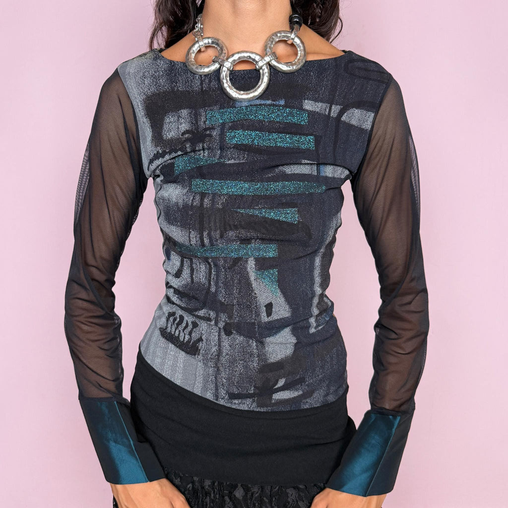 Vintage 2000s dark avant-garde top by Save the Queen, crafted from stretchy semi-sheer mesh with an abstract graphic print in black, charcoal grey, and blue tones. Features an asymmetric deconstructed construction, sheer long sleeves, and contrasting satin-like teal cuffs, creating a futuristic silhouette. Labelled as size M but also fits size S due to the stretchy fabric. Made in Italy from 100% polyamide. Excellent vintage condition.